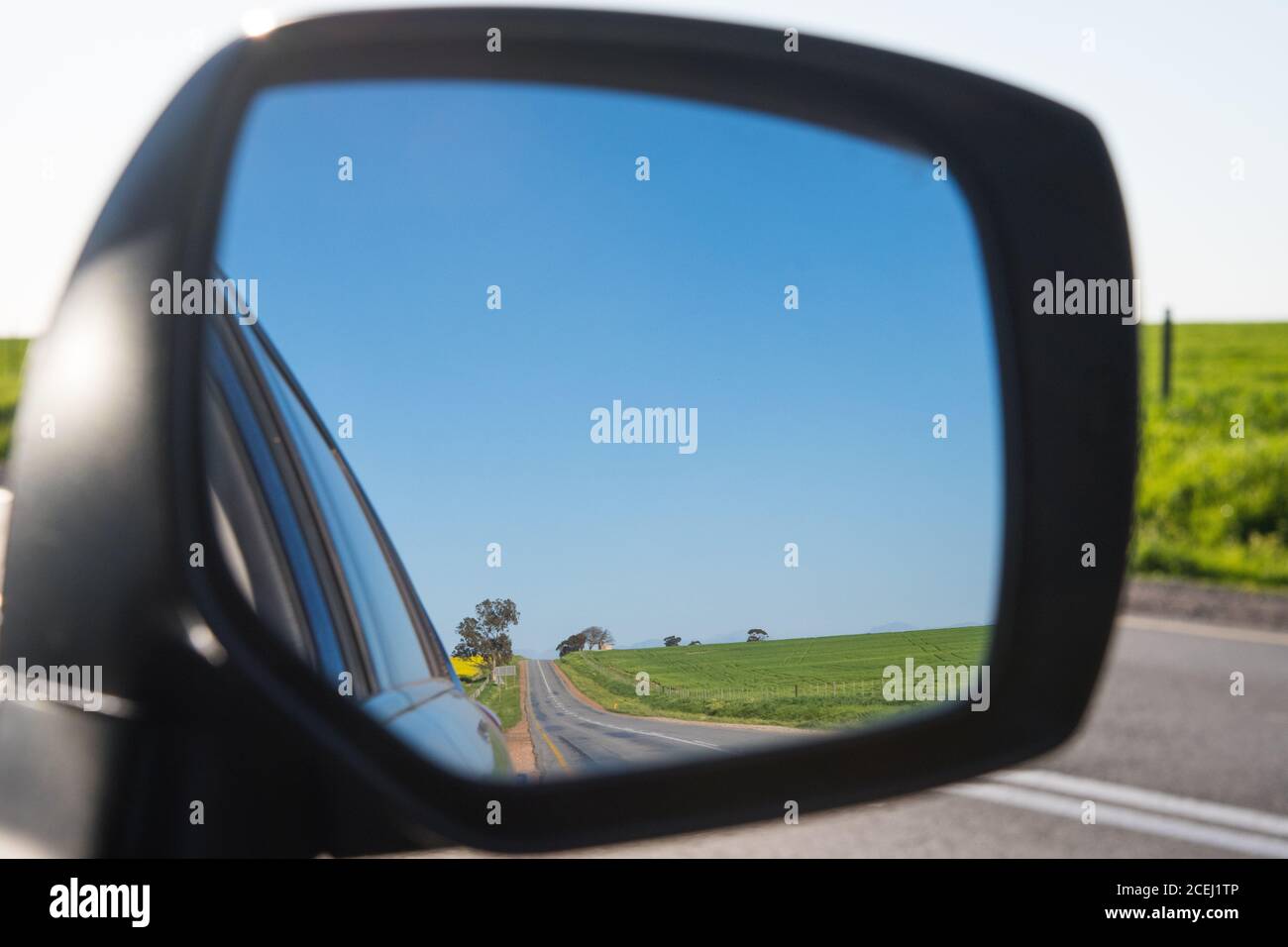 Strada di campagna nello specchietto retrovisore dell'auto Foto Stock