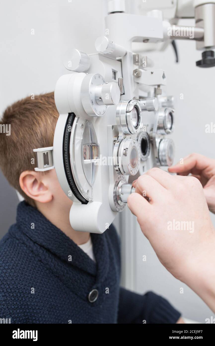 Ottico di test di un ragazzo agli occhi con dispositivi di Optometria Foto Stock