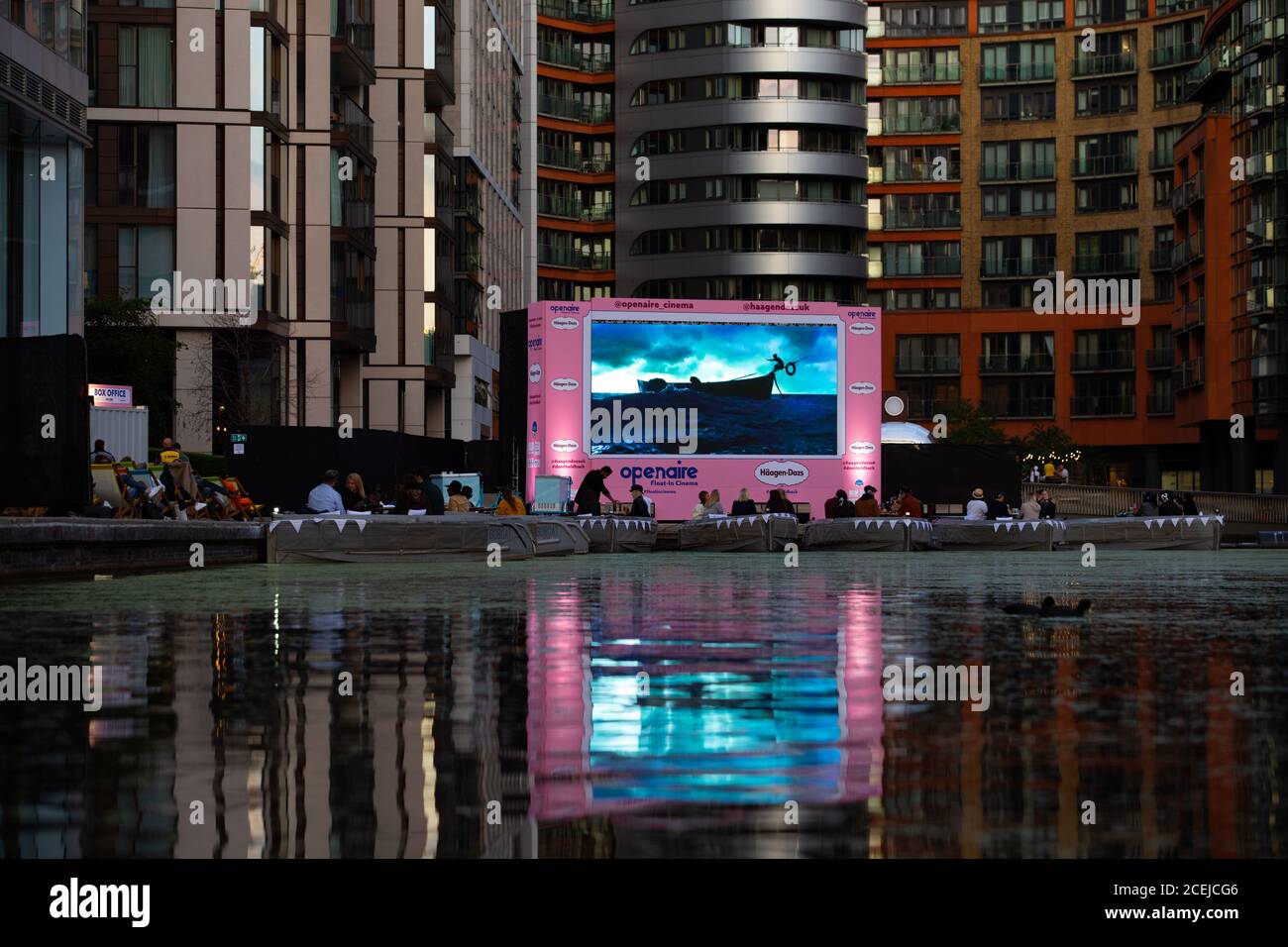 Un pubblico guarda un film all'OpenAIRE Float-in Cinema di H??agen-Dazs, che consiste in una flotta di eco-barche che forniscono posti a sedere per un massimo di 128 persone a Paddington Basin, Londra. Foto Stock