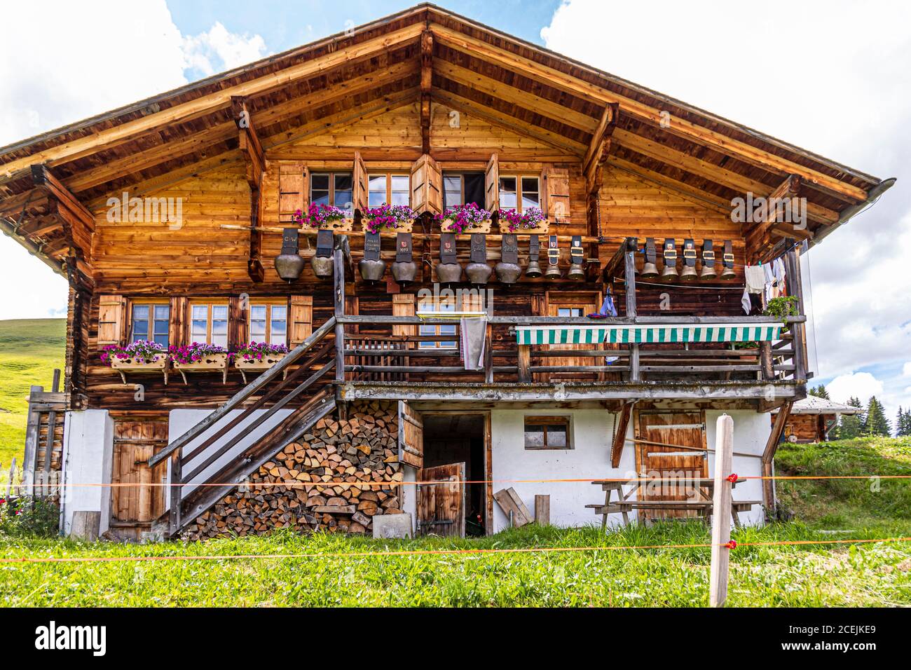 Una collezione di enormi campane è appesa alla casa principale dell'Alpe di Pöris. Da qui il Lenkerhof ottiene il suo formaggio di capra fresco. ALP Lairy, Lenk, Svizzera, Lenk, Svizzera Foto Stock
