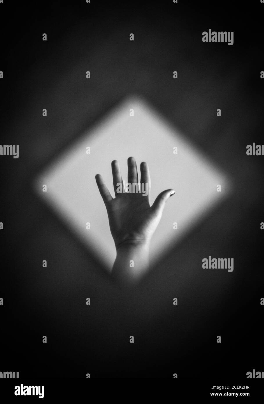 Un colpo bianco e nero di mano di raccolto che riflette in speculare Foto Stock