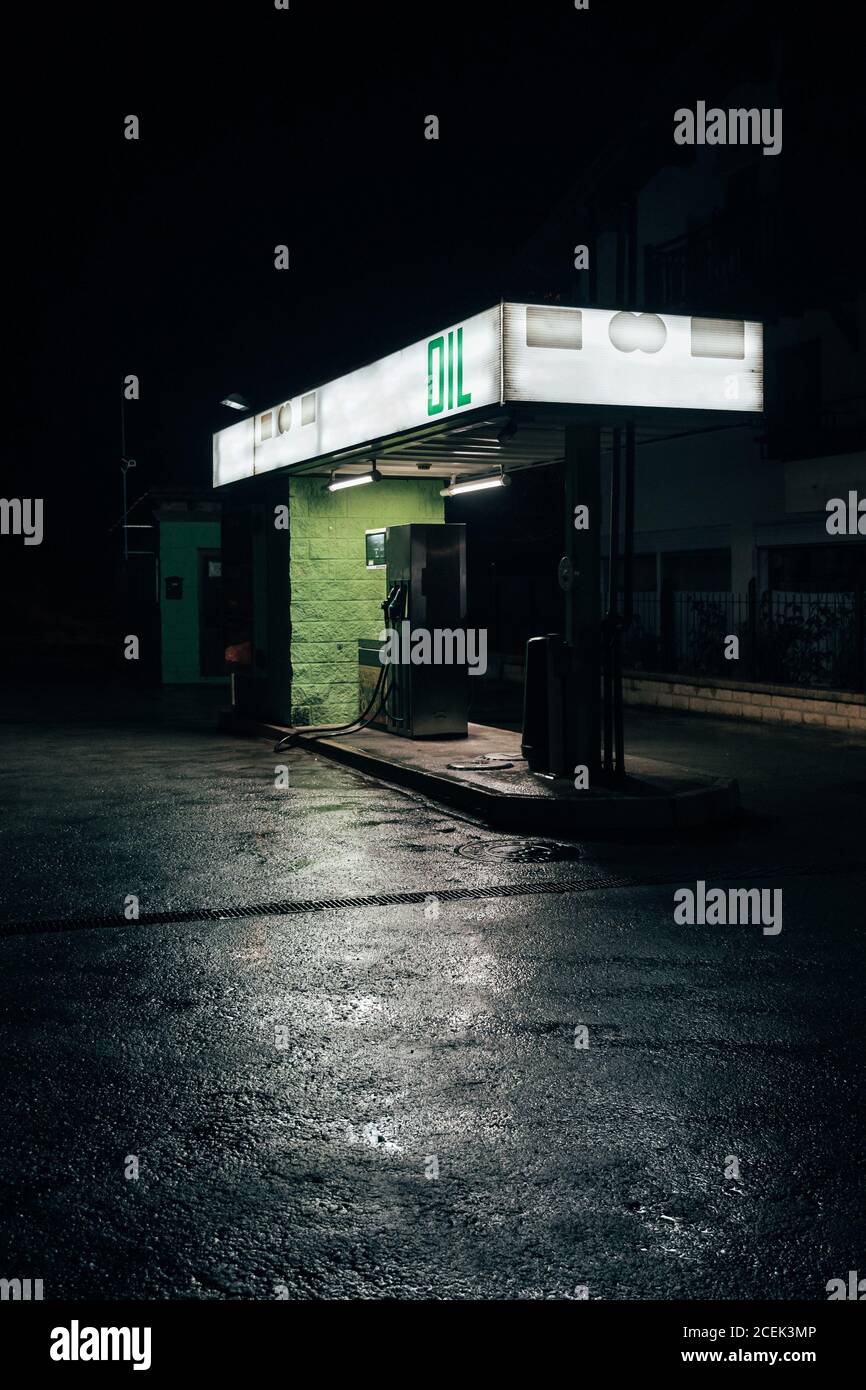 Piccola stazione di rifornimento dell'olio in piedi sul lato della strada a bella buia notte Foto Stock