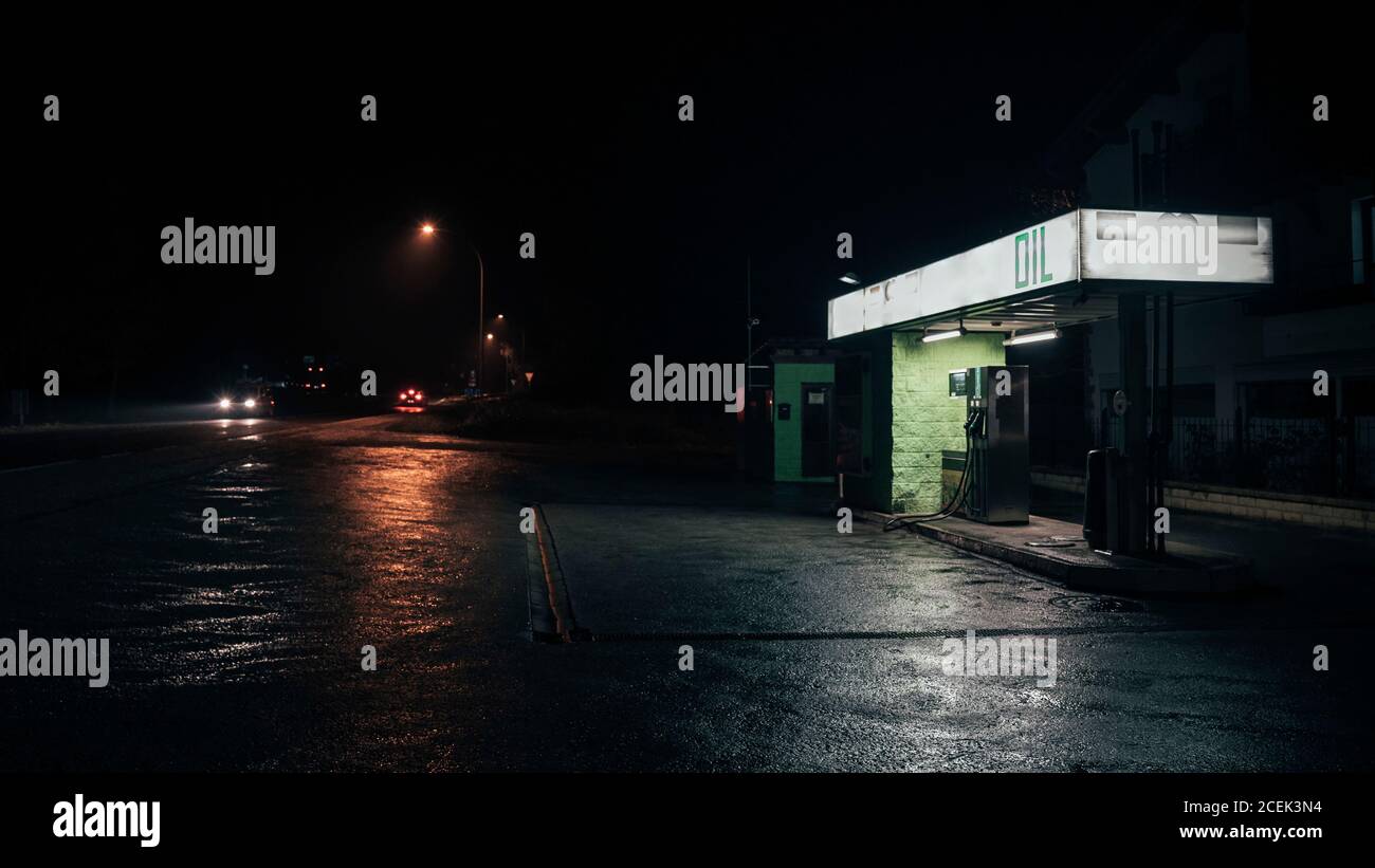 Piccola stazione di rifornimento dell'olio in piedi sul lato della strada a bella buia notte Foto Stock