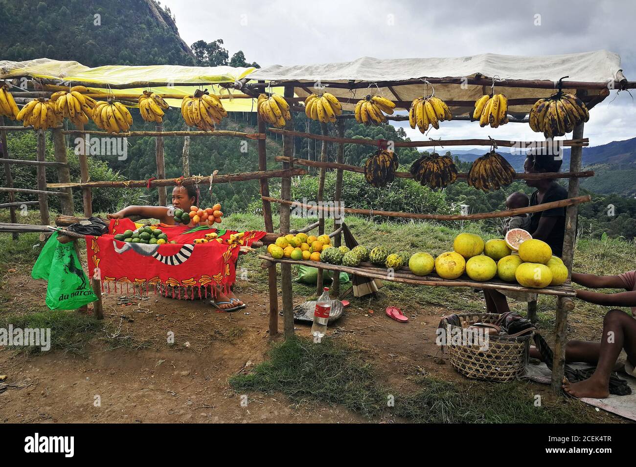 Mandraka, Madagascar - 24 aprile 2019: Sconosciuti abitanti malgascio che vendono banane, pomelo e altri agrumi in autostrada. Il cibo è venduto solitamente a. Foto Stock