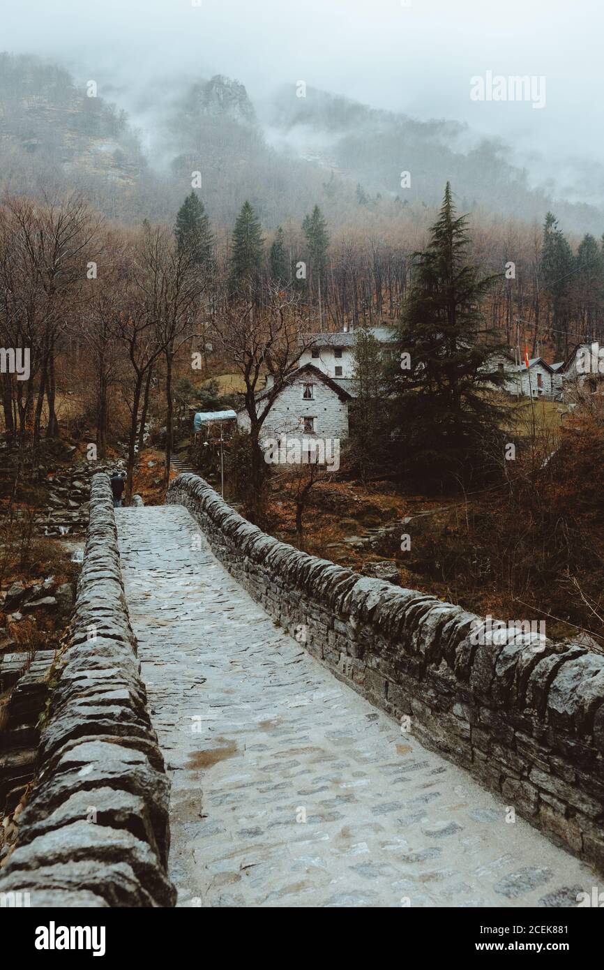 Piccolo ponte di pietra e case villaggio nella natura autunno. Foto Stock