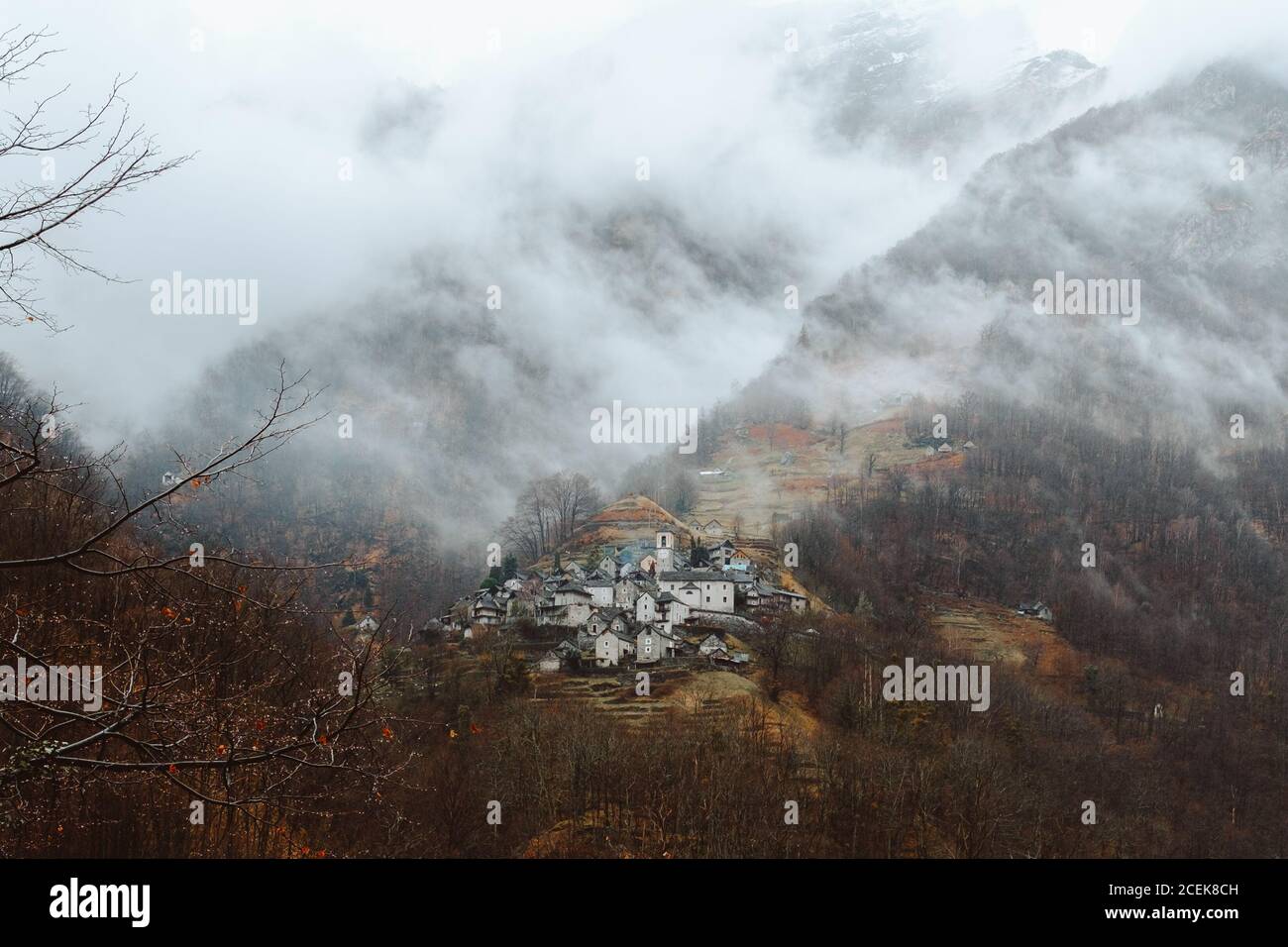 Piccoli edifici di villaggio posti su una montagna in un giorno foggy. Foto Stock