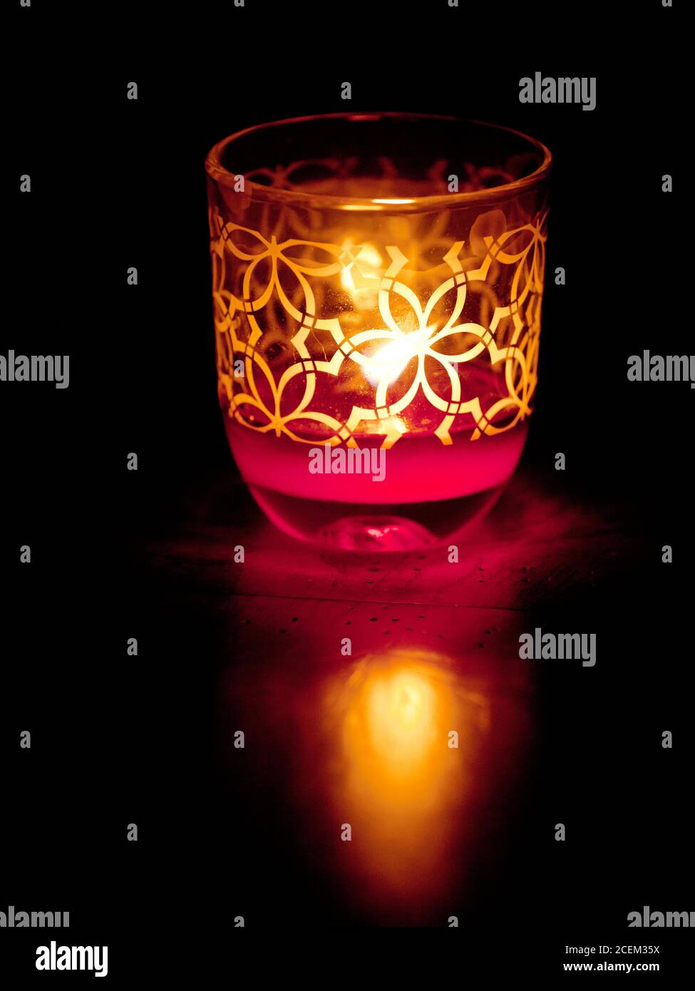 Una singola candela votiva illuminata al buio Foto Stock