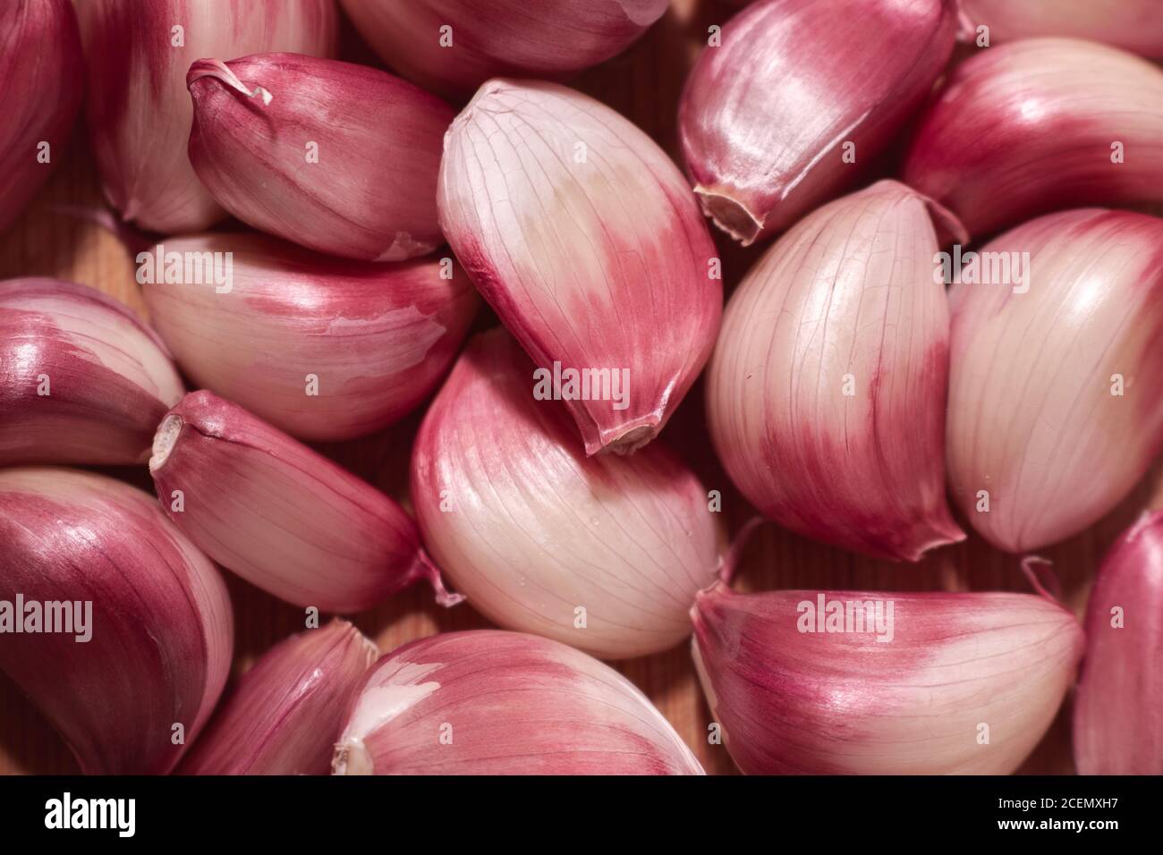 uno spicchio di aglio viola sciolto su sfondo di legno. Foto Stock
