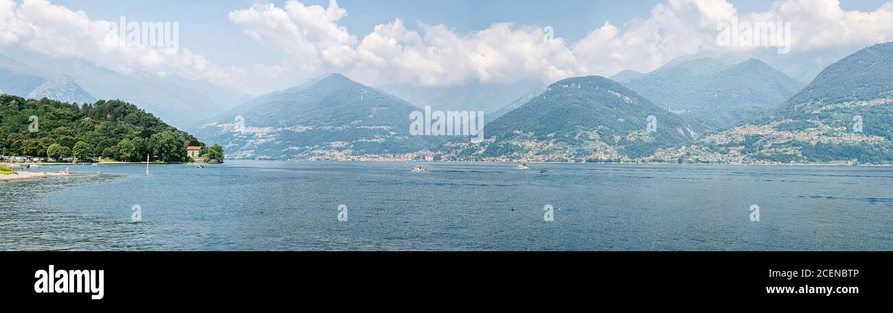 Paesaggio pittoresco sul Lago di Como con le cime delle Alpi sullo sfondo. Italia. Vista panoramica. Un magico paesaggio panoramico. Foto Stock