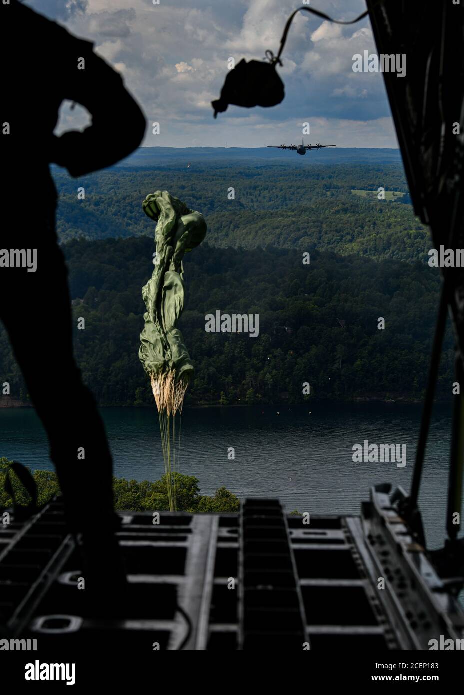 Un paracadute attaccato al carico si apre dopo essere stato spinto fuori dalla parte posteriore di un aereo C-130H Hercules da un maestro di carico il 23 agosto 2020, sopra il lago di Summerville, West Virginia. Cinque unità di riserva dell'aeronautica della ventiduesima unità dell'aeronautica e di una Guardia nazionale dell'aria della Virginia occidentale hanno partecipato al Rally nella valle, un'esercitazione di addestramento del C-130 multi-giorno sotto un concetto distribuito di operazioni, 22-25 agosto 2020. L'esercizio includeva gocce di carico, gocce di paracadutisti ad alta quota, rifornimento della task force ed estrazione del personale. (STATI UNITI Air Force photo/Senior Airman Christina Russo) Foto Stock