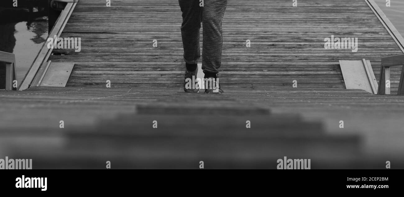 Immagine in scala di grigi di un maschio che sala le scale Foto Stock