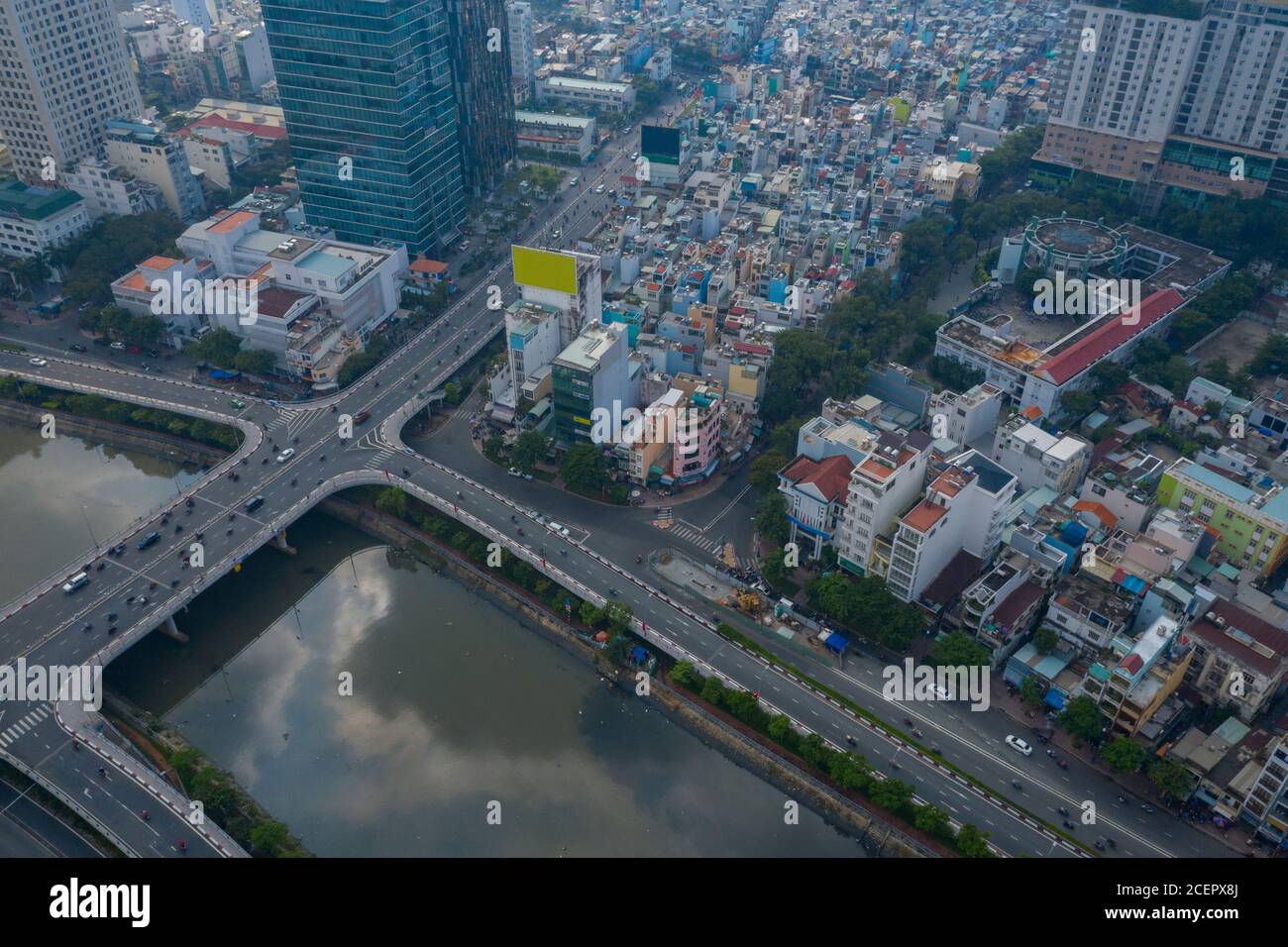 Vista grandangolare sul canale ben Nghe con Saigon, skyline della città del Vietnam, ponte di Calmette e traffico diurno al mattino Foto Stock