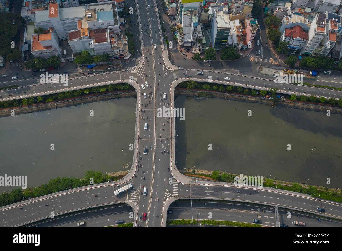 Vista simmetrica del drone del canale ben Nghe con Saigon, il ponte di Calmette e il traffico mattutino Foto Stock