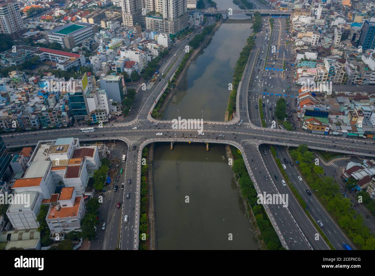 Vista simmetrica del drone del canale ben Nghe con Saigon, skyline della città del Vietnam Ong Lanh e ponti Calmette e traffico mattutino foggoso Foto Stock