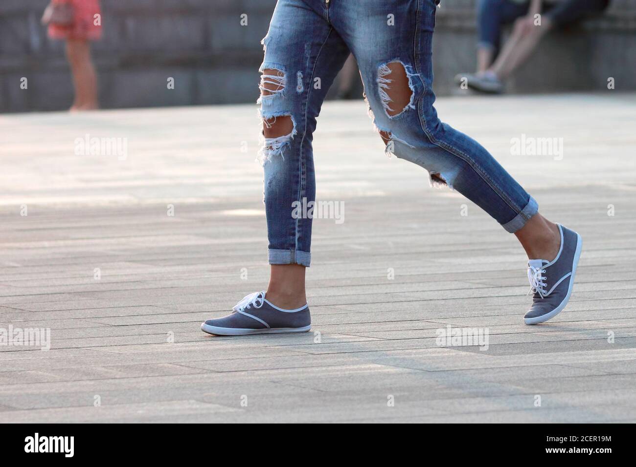 uomo che cammina in jeans strappati Foto stock - Alamy