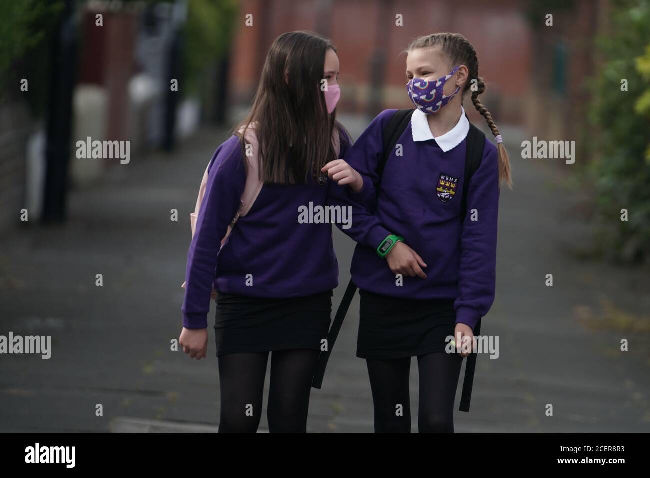 Kadie Lane (a destra), 11, e Brooke Howourth, 11, a piedi a Marden Bridge Middle School a Whitley Bay, Tyne e indossare, per il loro primo giorno di mandato, come le scuole in Inghilterra riaprono agli studenti dopo il blocco coronavirus. Foto Stock