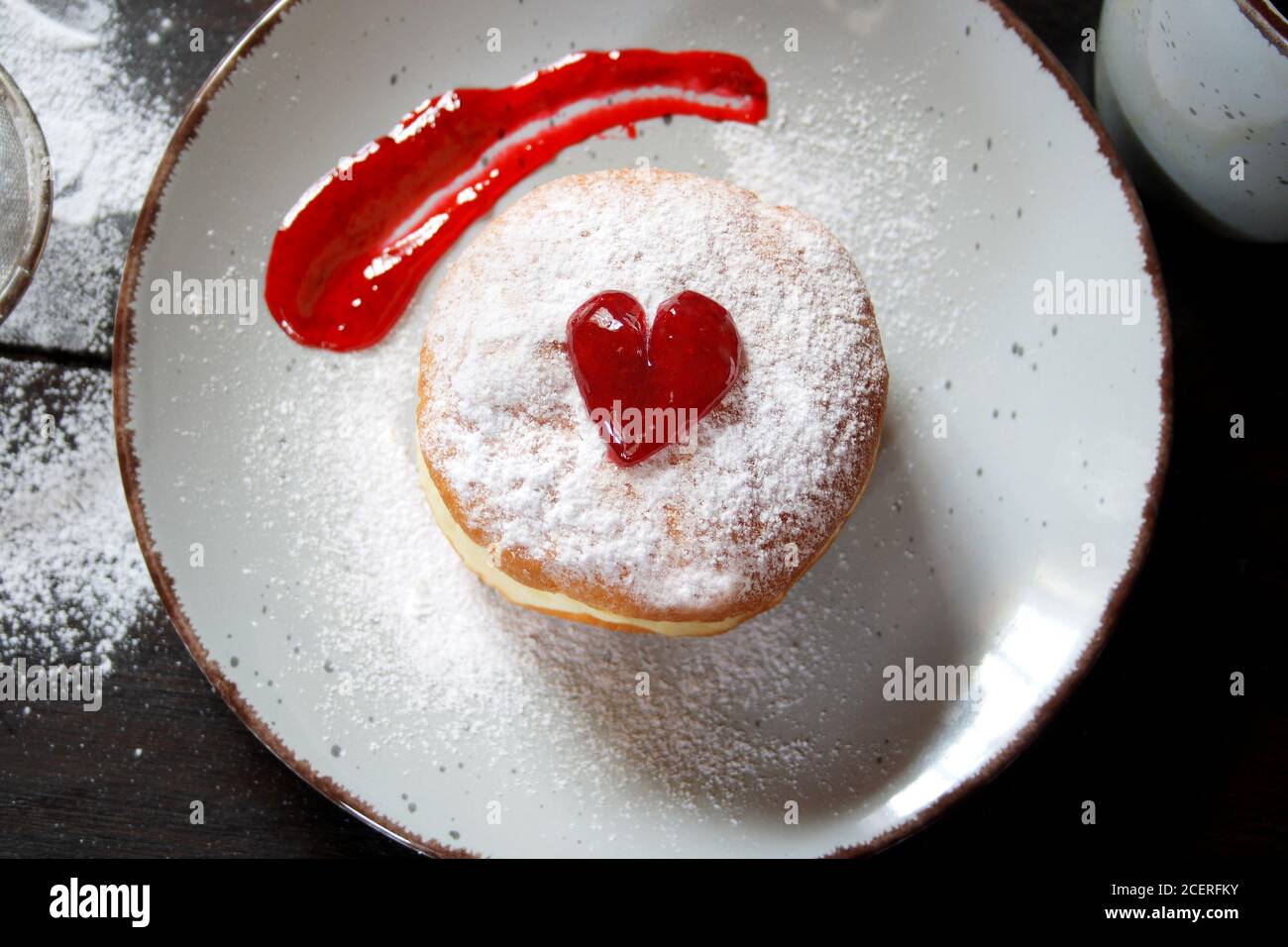 Ciambella riempita di gelatina con zucchero in polvere su una piastra di ceramica. Vista dall'alto Foto Stock