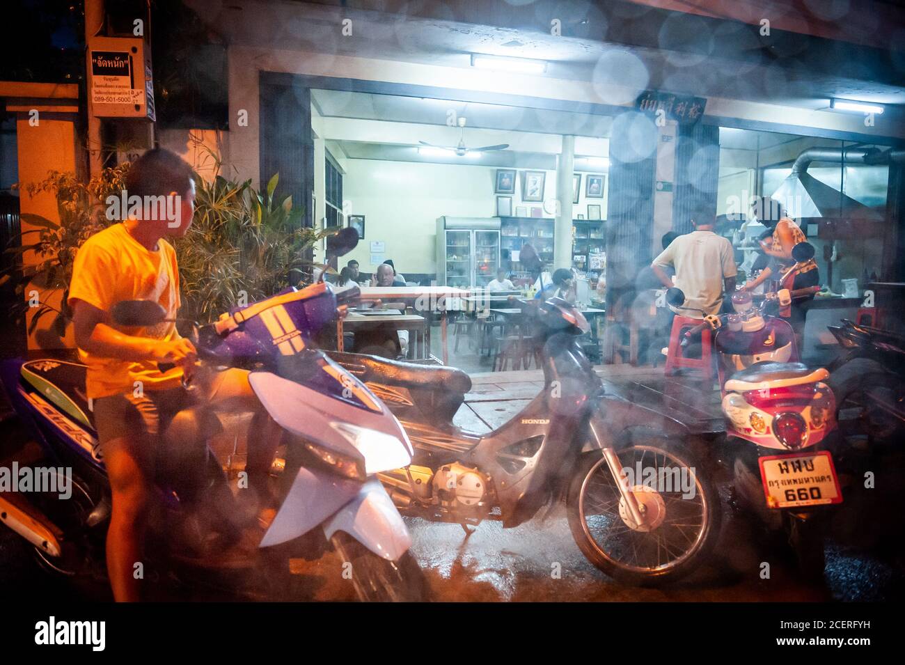 Un piccolo ristorante tailandese a conduzione familiare aperto per affari durante una pesante caduta di pioggia in una strada laterale fuori Sukhumvit Rd. Bangkok, Thailandia. Foto Stock