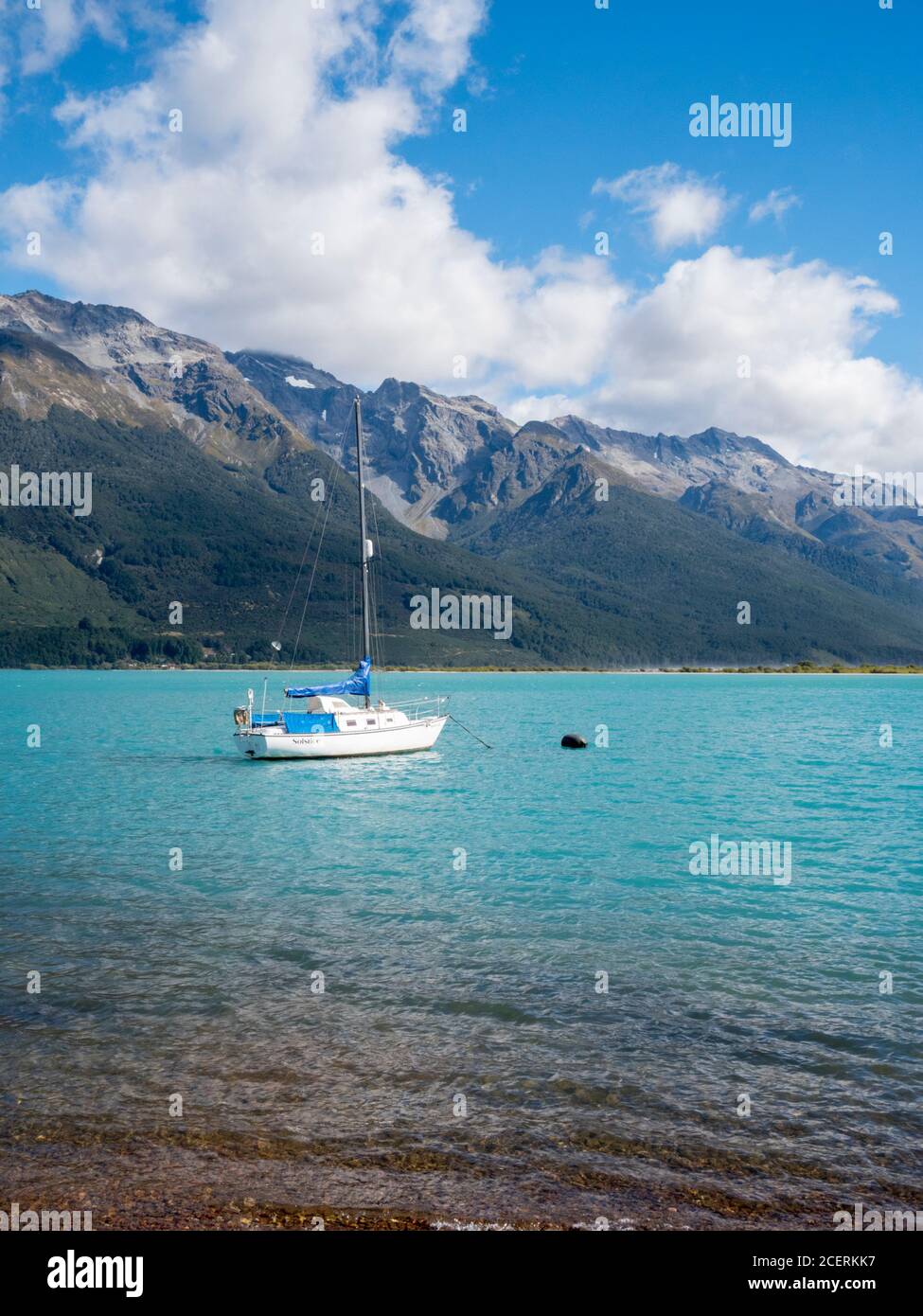 Uno yacht ormeggiato sulle acque blu del lago Wakatipu Circondato da montagne a Glenorchy Nuova Zelanda Foto Stock