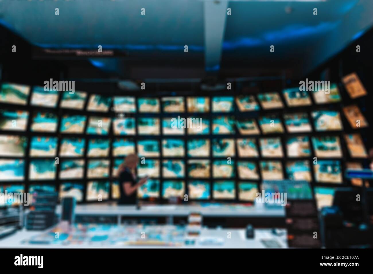 Il concetto di videosorveglianza. Ufficio con un dipendente sullo sfondo di  molti monitor collegati a telecamere TVCC. Sfocatura Foto stock - Alamy