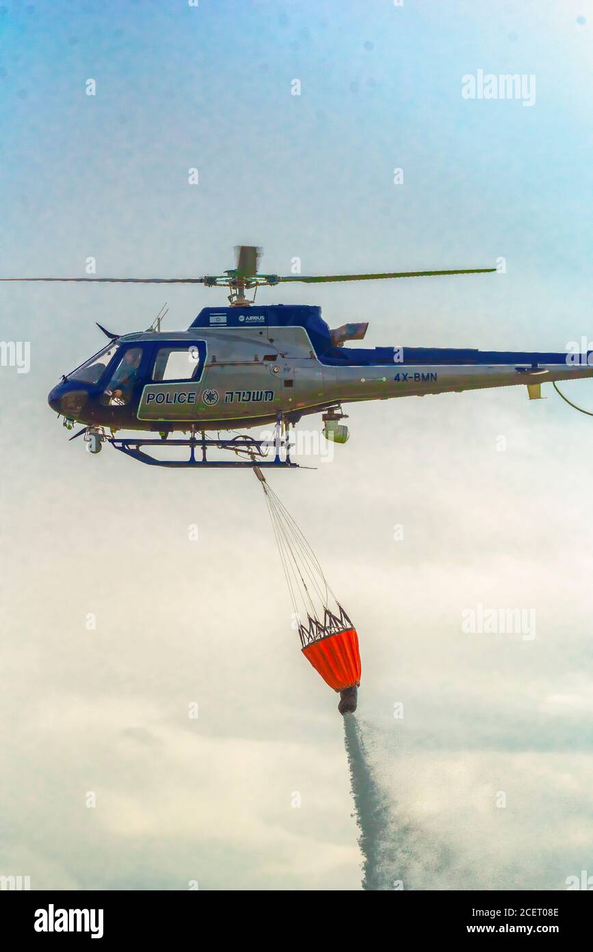 Un elicottero di polizia è utilizzato durante un incendio trapano a. Acqua dell'ascensore alla zona di fuoco l'acqua viene fatta cadere nell'area richiesta Foto Stock