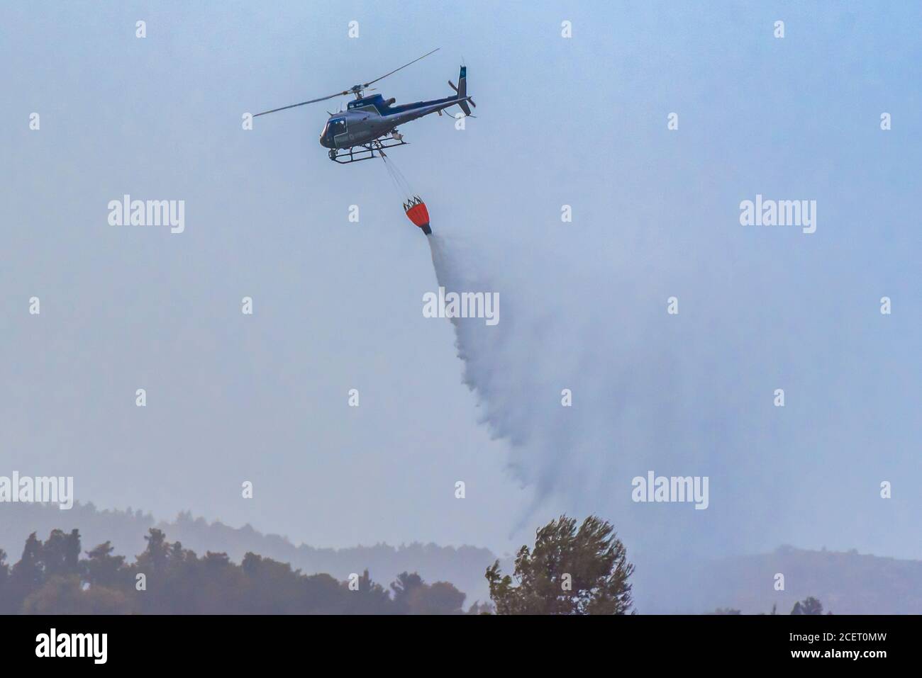 Un elicottero di polizia è utilizzato durante un incendio trapano a. Acqua dell'ascensore alla zona di fuoco l'acqua viene fatta cadere nell'area richiesta Foto Stock