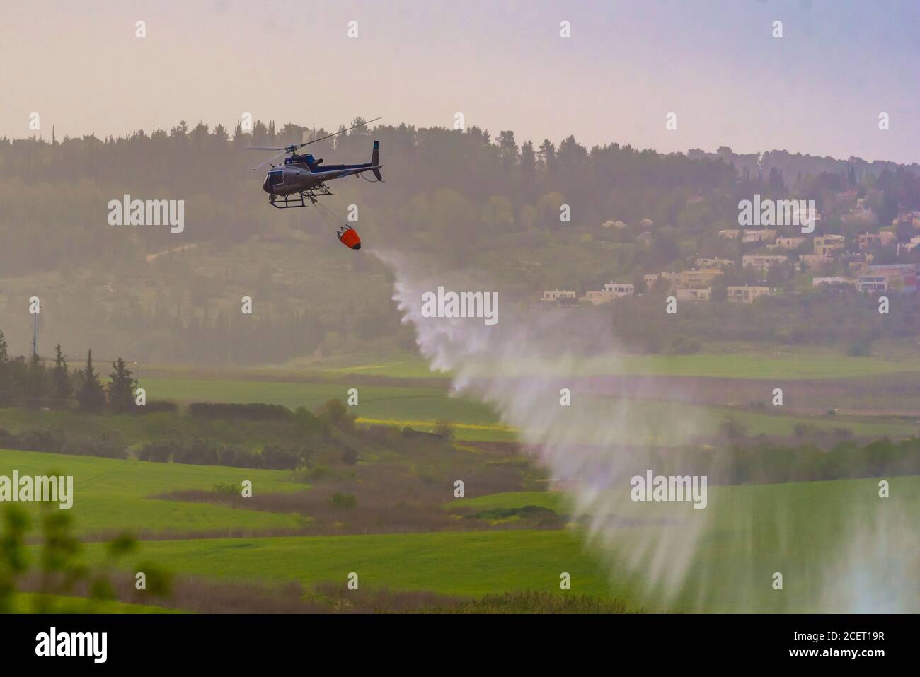 Un elicottero di polizia è utilizzato durante un incendio trapano a. Acqua dell'ascensore alla zona di fuoco l'acqua viene fatta cadere nell'area richiesta Foto Stock
