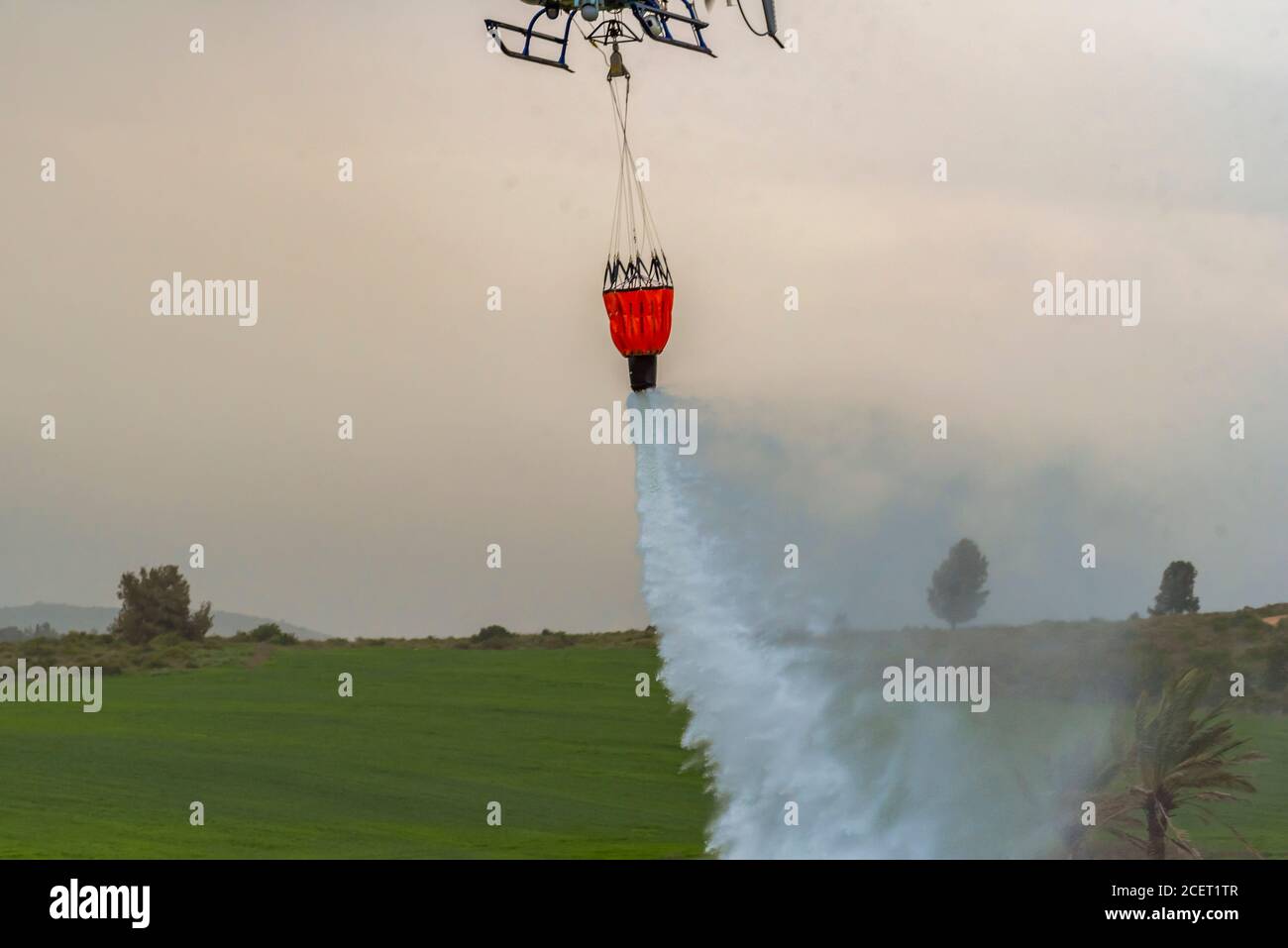 Un elicottero di polizia è utilizzato durante un incendio trapano a. Acqua dell'ascensore alla zona di fuoco l'acqua viene fatta cadere nell'area richiesta Foto Stock