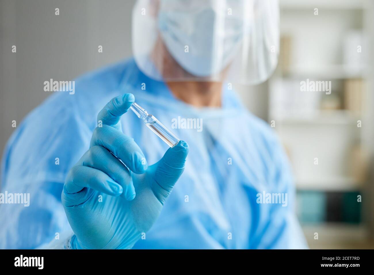 Testa tagliata primo piano di un lavoratore medico irriconoscibile che indossa personale ampolla protettiva uniforme con vaccino Foto Stock