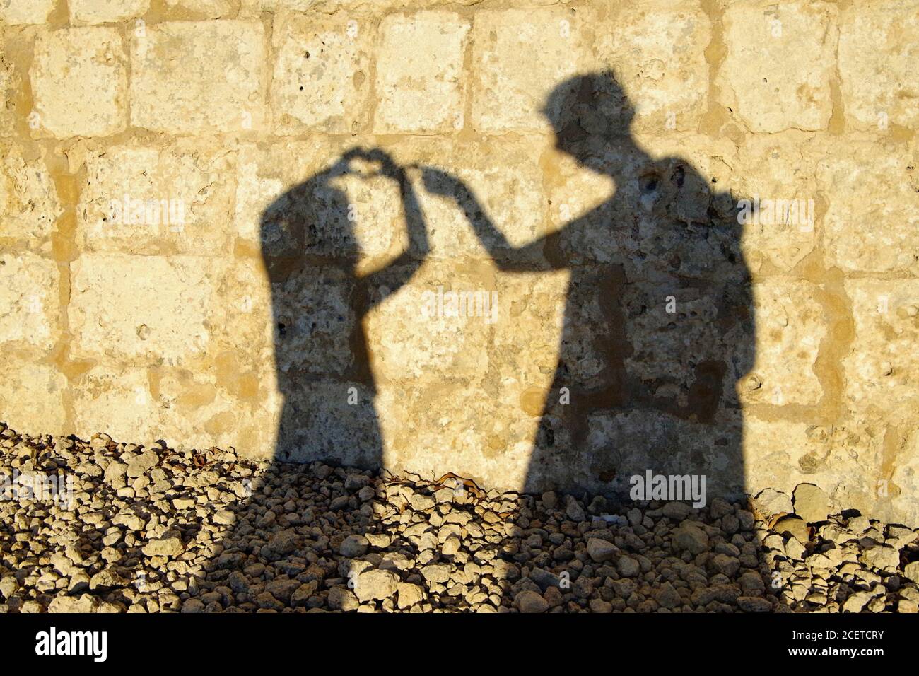 Ombra di madre e figlia, gettata sul muro, Mdina, Malta Foto Stock