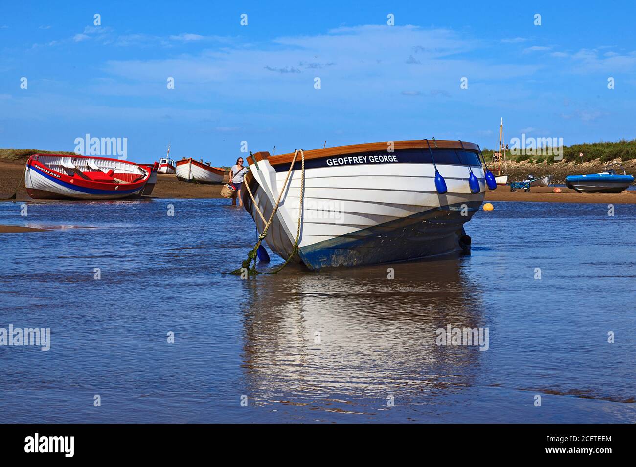 Barche a bassa marea a Burnham-Overy-Staithe sulla costa di Norfolk, Regno Unito Foto Stock
