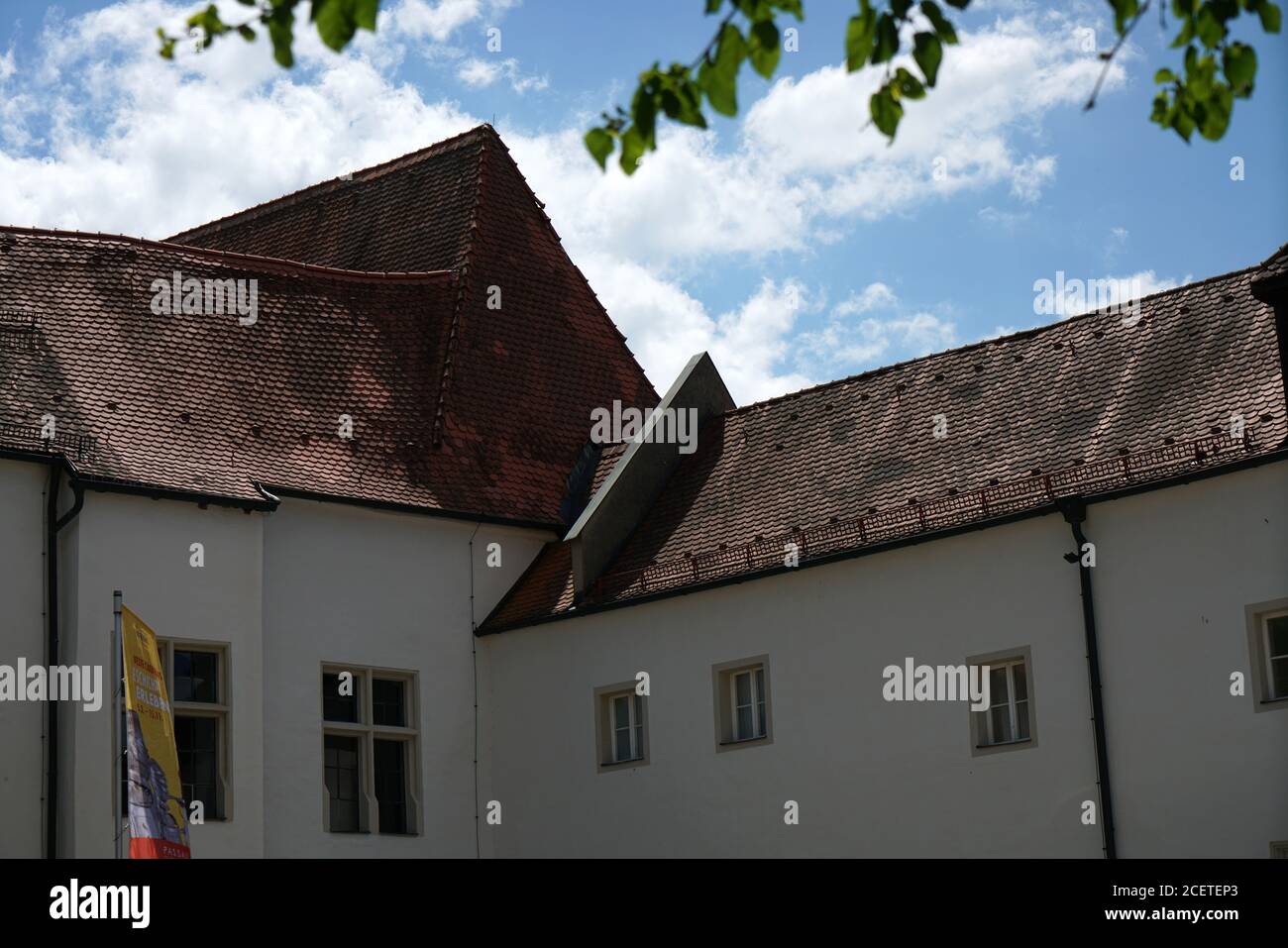 Vista di un vecchio tetto di tegole di una casa su un sottile sfondo cloud Foto Stock