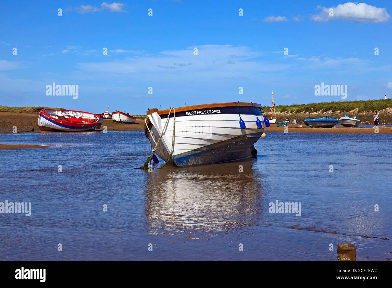 Barche a bassa marea a Burnham-Overy-Staithe sulla costa di Norfolk, Regno Unito Foto Stock
