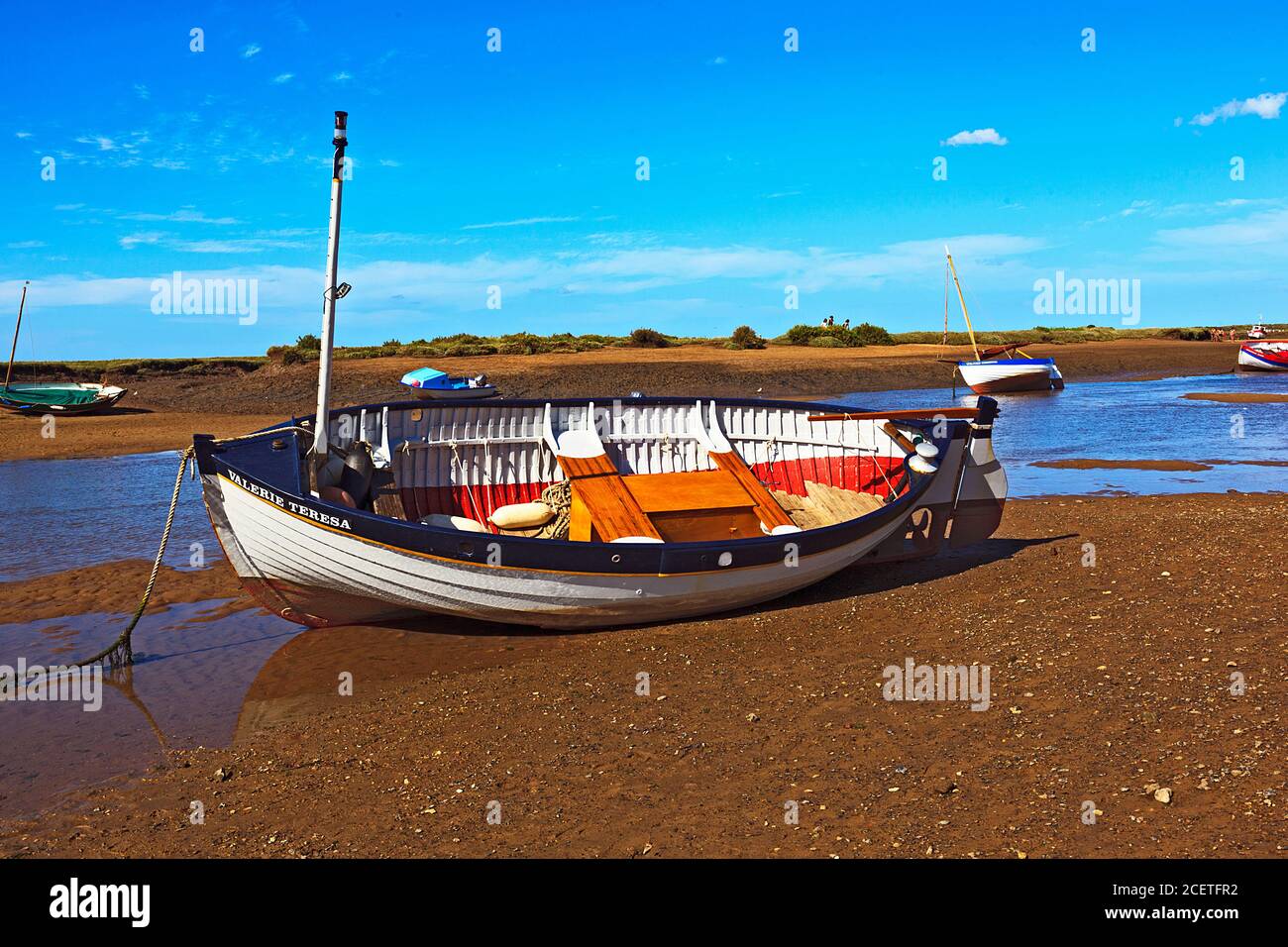 Barca in barca a bassa marea a Burnham-Overy-Staithe sulla costa di Norfolk, Regno Unito Foto Stock