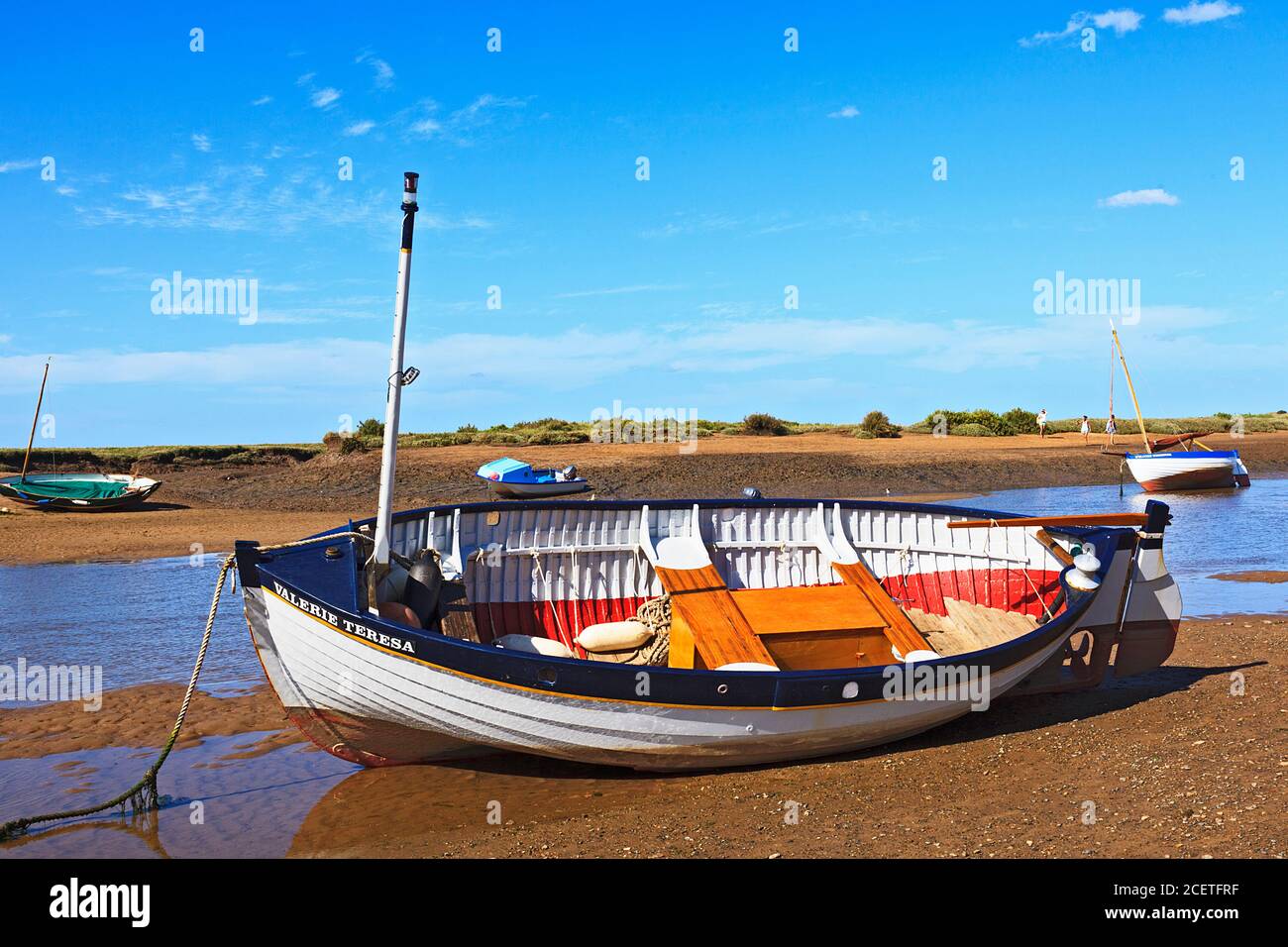 Barca in barca a bassa marea a Burnham-Overy-Staithe sulla costa di Norfolk, Regno Unito Foto Stock