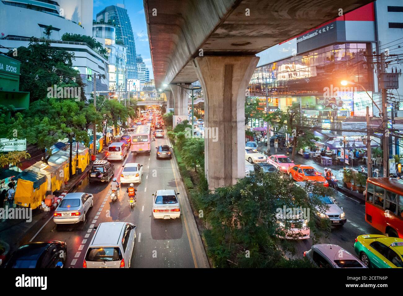 Guardando giù sulla congestionata Sukhumvit Rd vicino al raccordo di Asoke al crepuscolo. Ripresa da un percorso sopraelevato che attraversa la strada. Bangkok Thailandia. Foto Stock