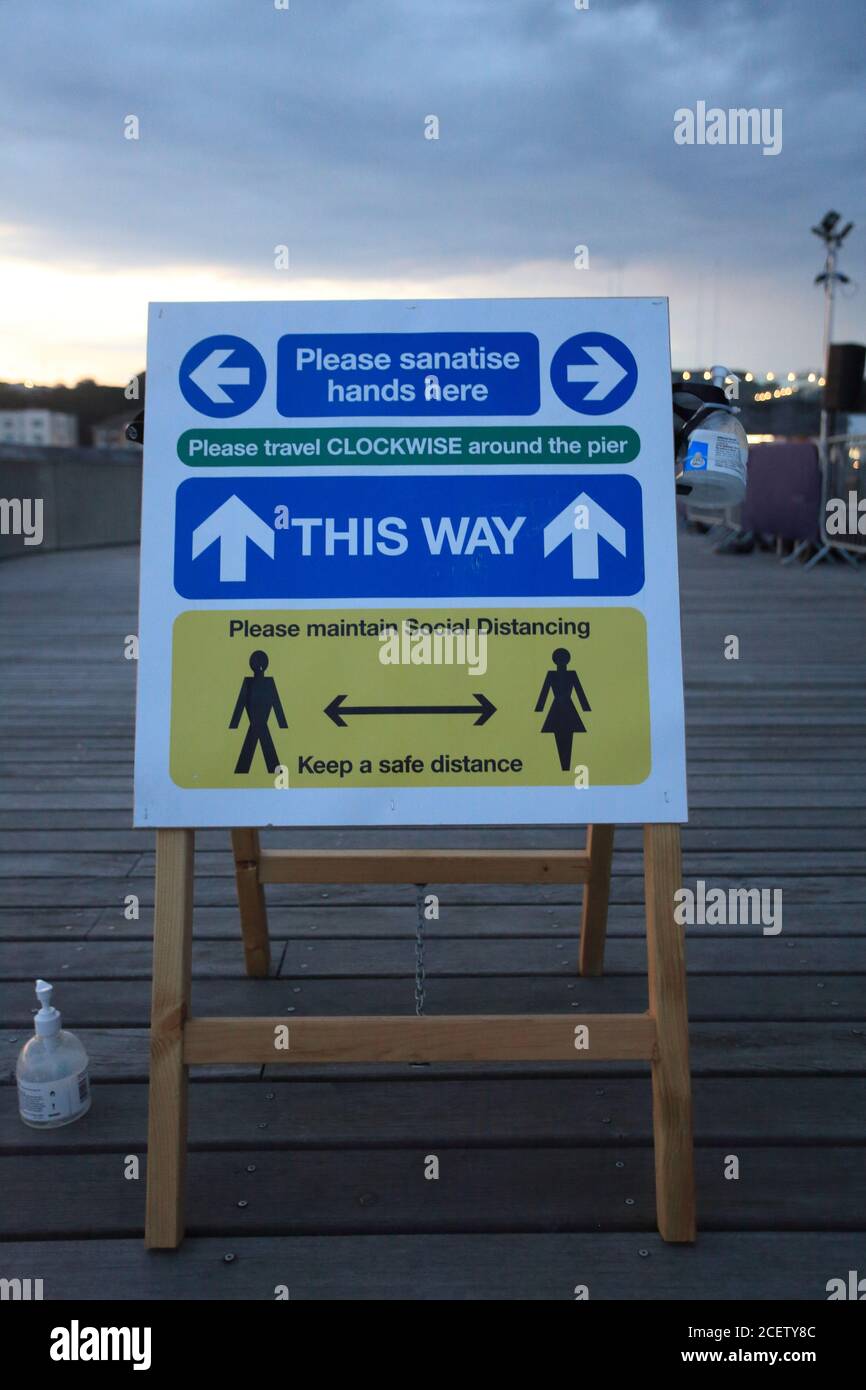 Social distancing board sul molo di Hastings, East Sussex, Regno Unito Foto Stock