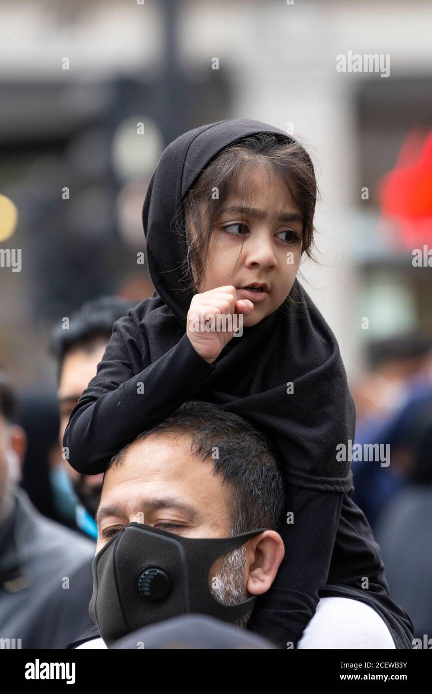 Una giovane ragazza che cavalcava il piggyback durante l'evento Ashura Day per i musulmani sciiti, Oxford Circus, Londra, 30 agosto 2020 Foto Stock