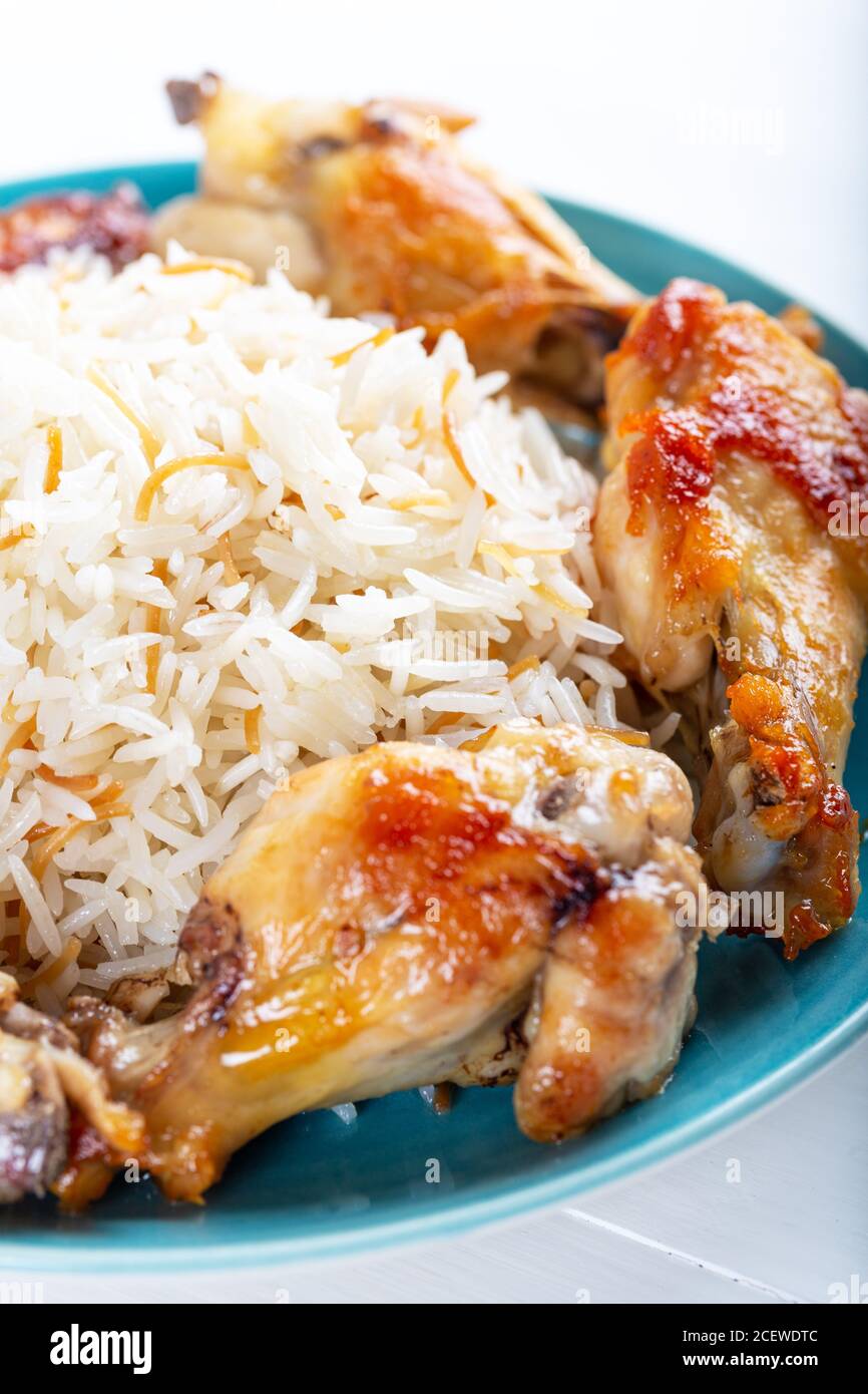 Ali di pollo grigliate con riso basmati. Foto Stock