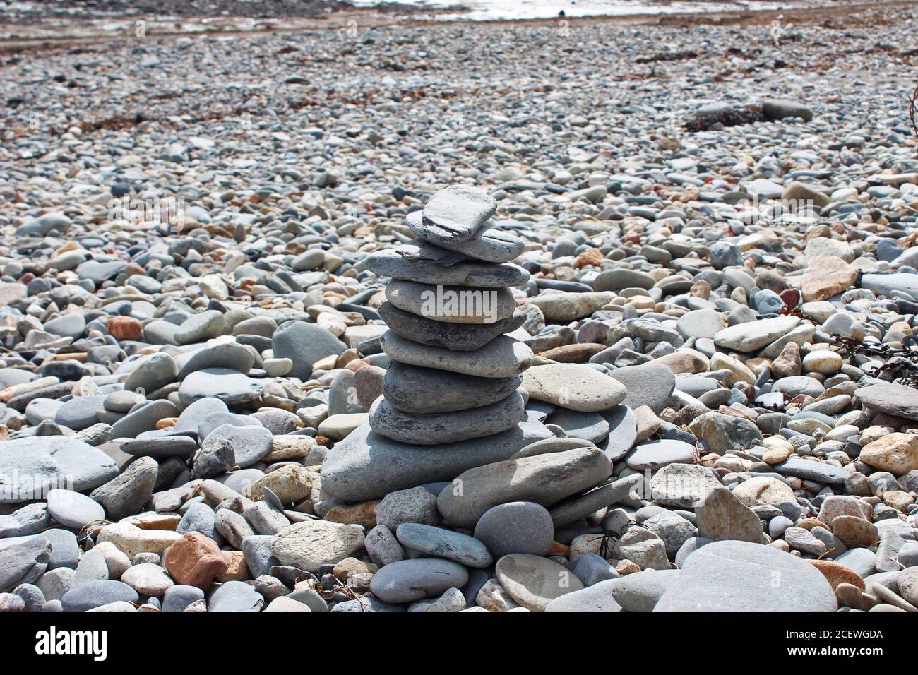 Torre di ciottoli in equilibrio su una spiaggia di ciottoli a Criccieth, Galles del Nord Foto Stock