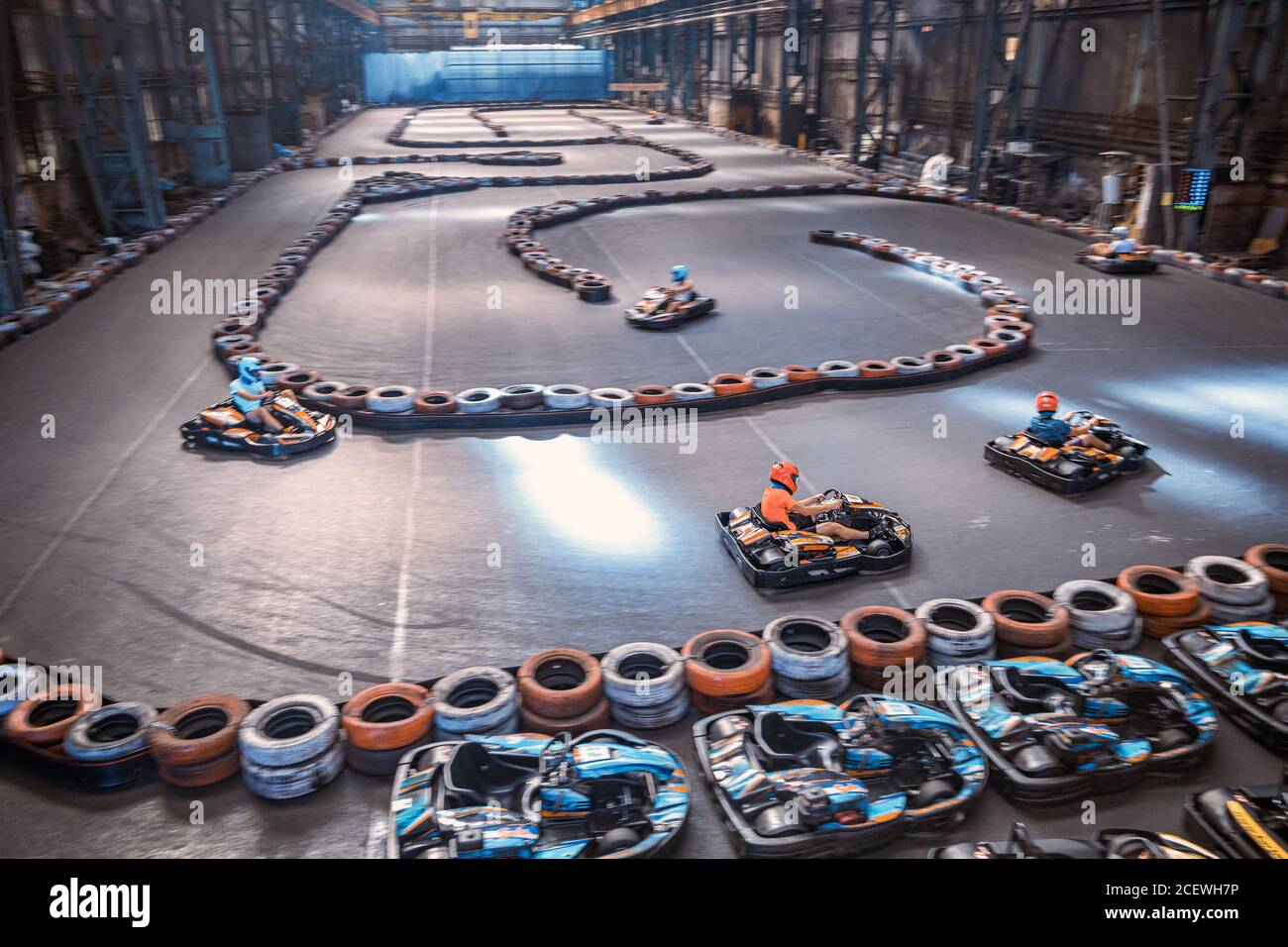 Tre ragazzi si sorpasso su una pista di karting interna Foto Stock