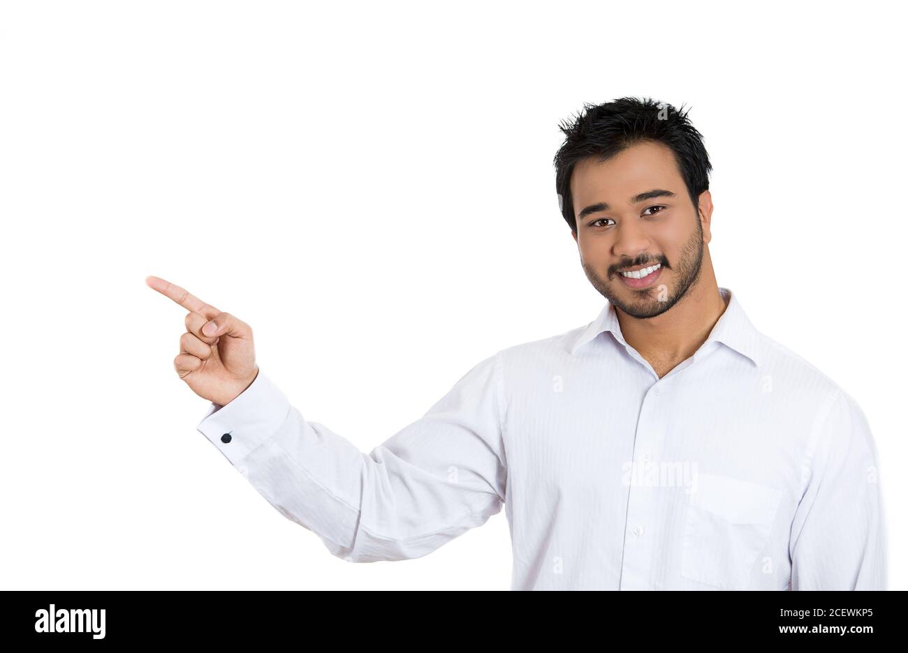 Primo piano ritratto di felice giovane uomo sorridente con barba che punta allo spazio a sinistra isolato su sfondo bianco. Segno positivo di emozione umana, fa Foto Stock