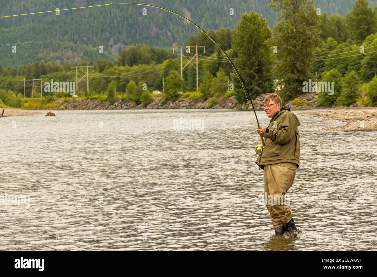 Un pescatore di mosca agganciato in un salmone sul fiume Kitimat, nella Columbia Britannica, Canada Foto Stock