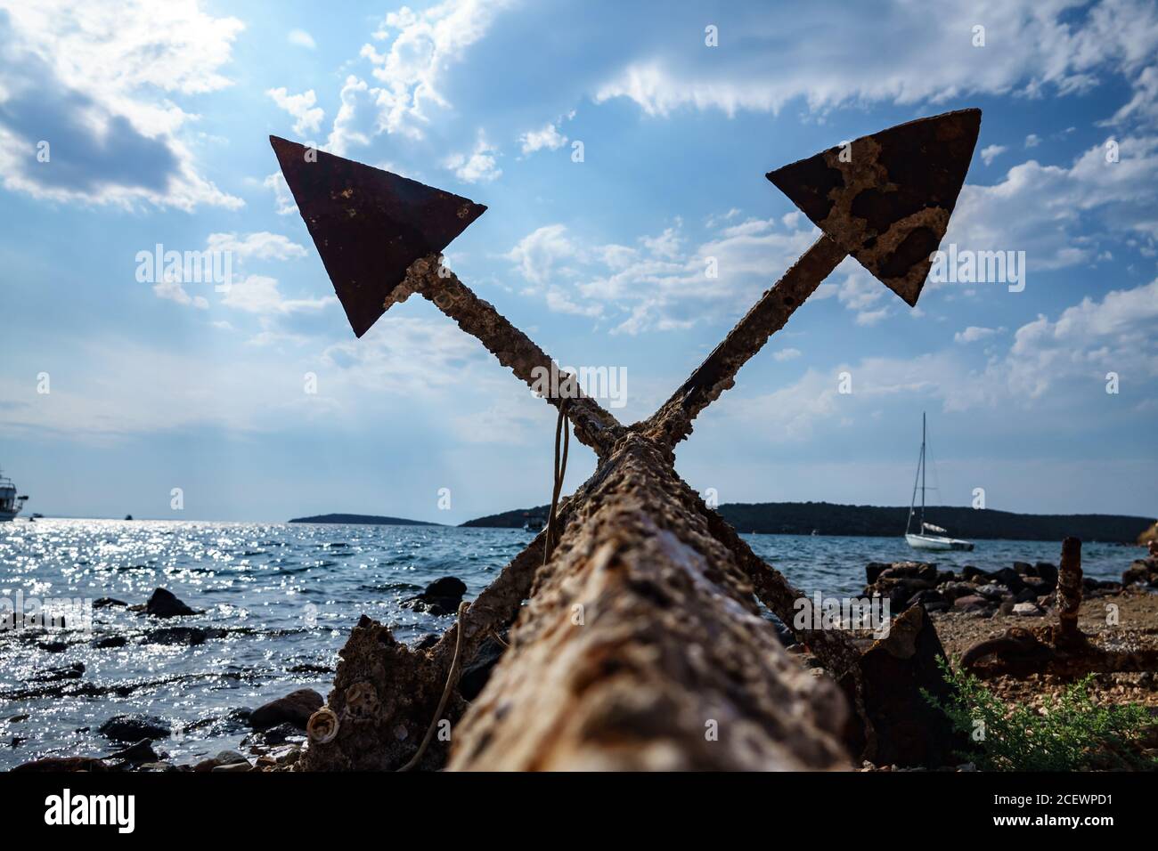 Vecchia ancora arrugginita inutilizzata sulla riva del mare Foto Stock