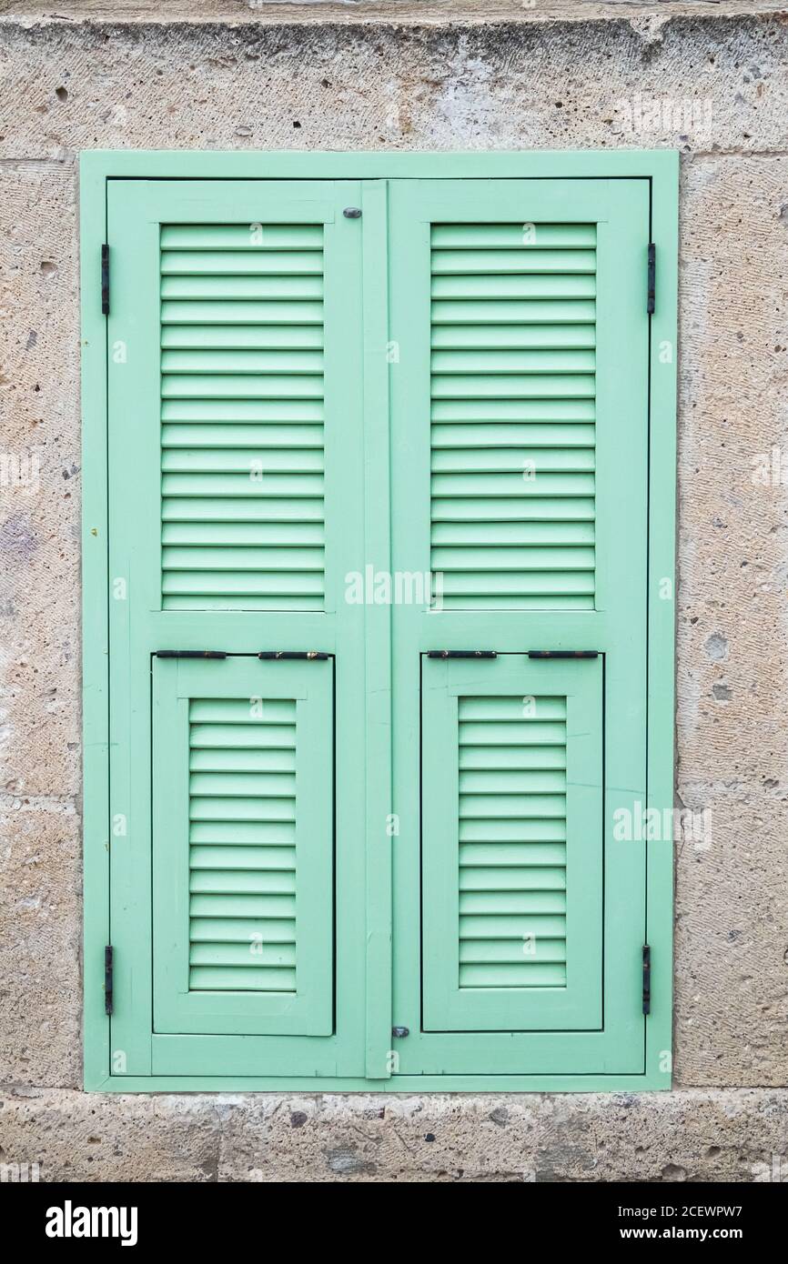 Finestra turchese su parete in pietra. Foto Stock