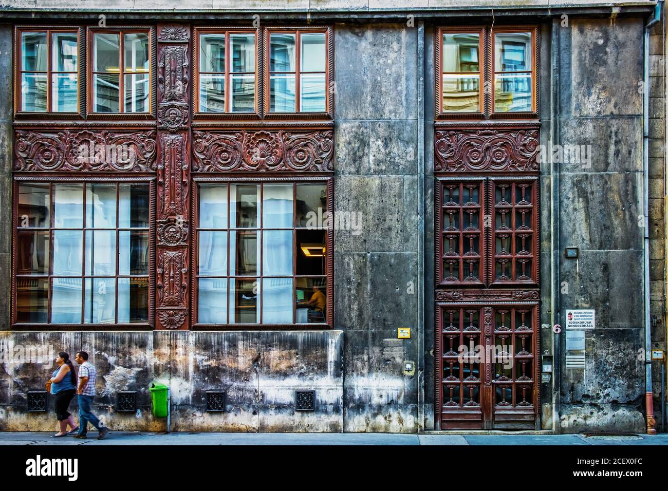 Ungheria, Budapest, 2019 agosto, una coppia a piedi dalla facciata della casa di cura in via 6 Nádor Foto Stock