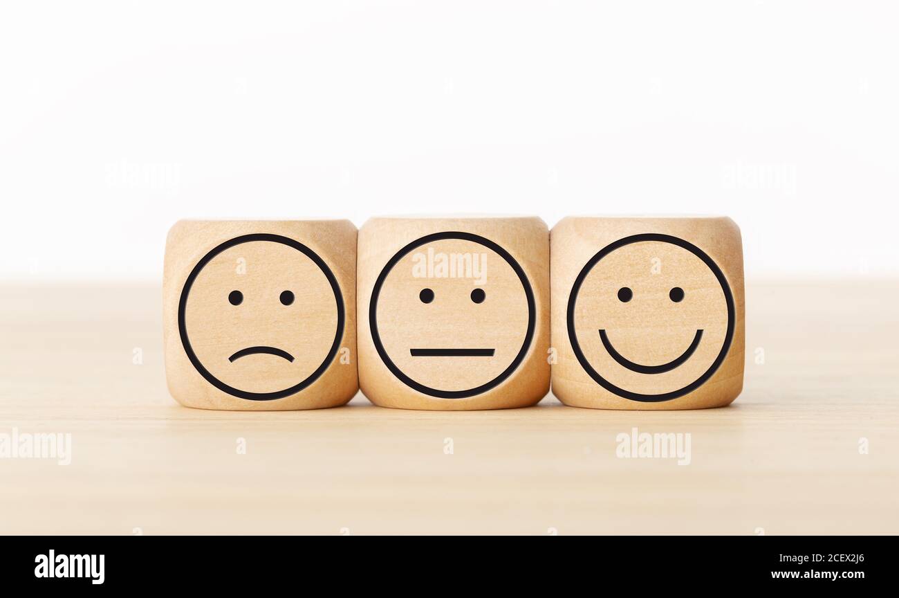 Feedback sull'assistenza agli utenti, valutazione della revisione dei clienti, sondaggio, concetto di sondaggio sulla soddisfazione. Blocchi di legno con espressioni facciali Foto Stock