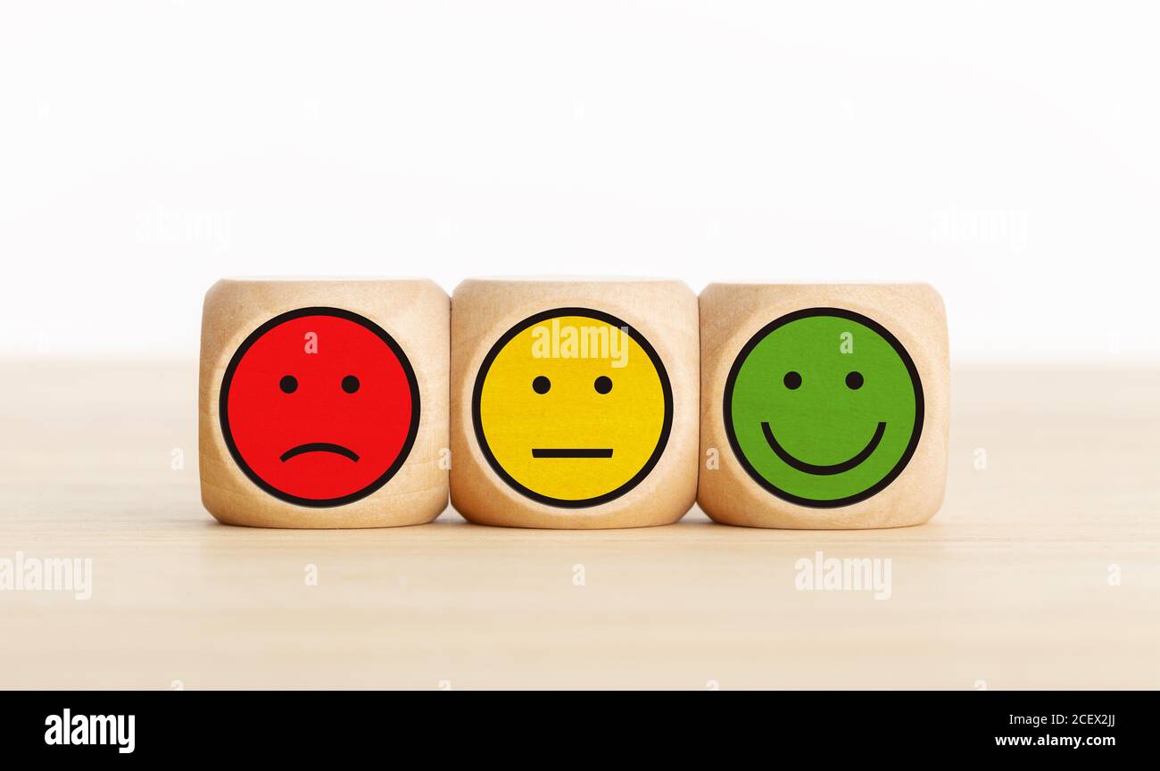 Feedback sull'assistenza agli utenti, valutazione della revisione dei clienti, sondaggio, concetto di sondaggio sulla soddisfazione. Blocchi di legno con espressioni facciali Foto Stock