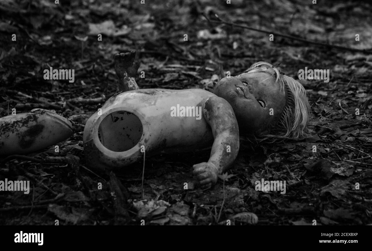 Una foto in bianco e nero di un broken doll al di fuori di un kindertgarten abbandonati. Foto Stock