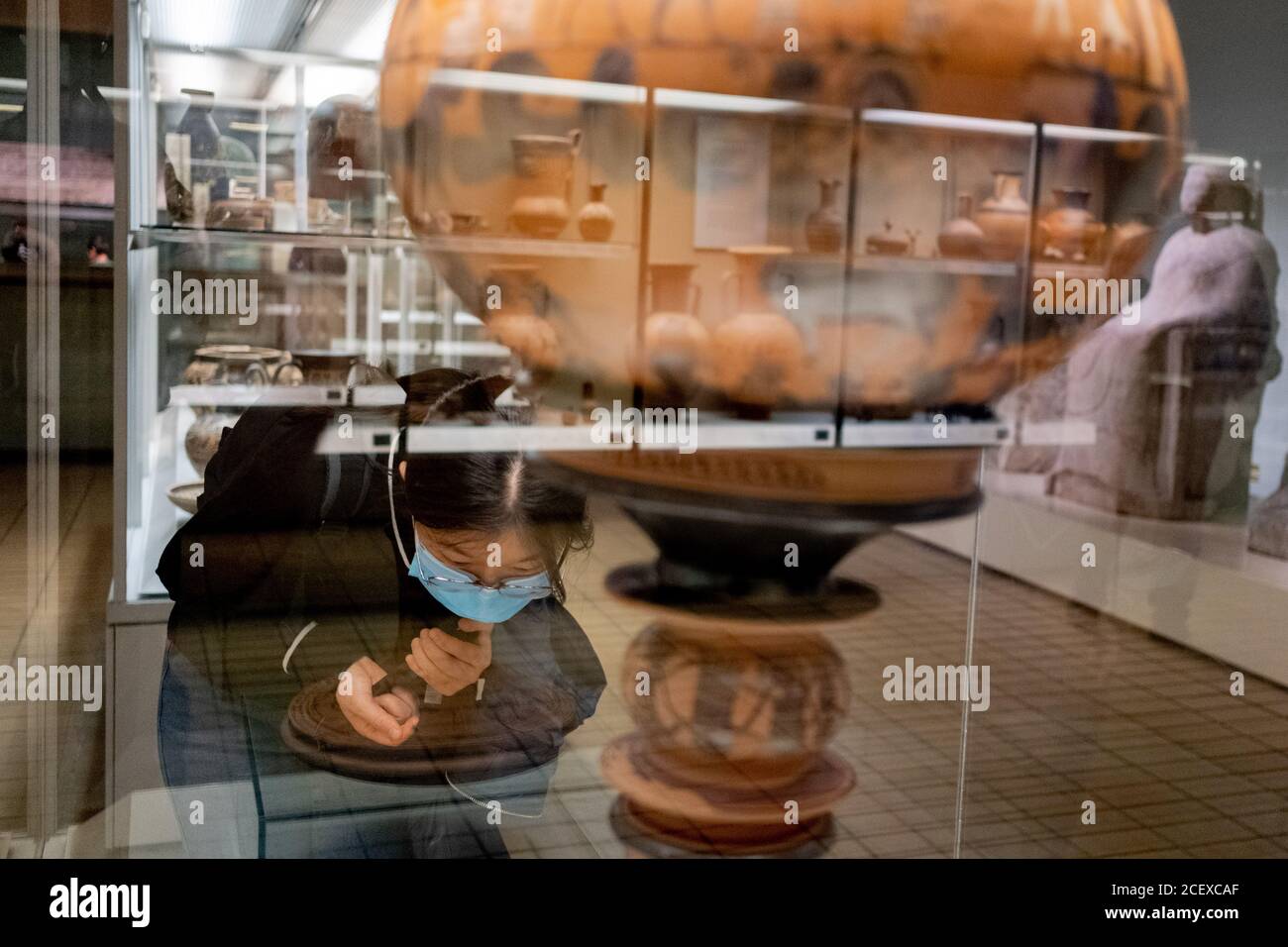 Ora riaperto dopo mesi di chiusura durante la pandemia di Coronavirus, un visitatore del British Museum che indossa una faccia coperta legge le descrizioni di un antico vaso greco che raffigura il matrimonio di Peleus e Tetis con animali immaginari (Atene, c580BC) dal pittore, Sophilos, il 2 settembre 2020, a Londra, Inghilterra. Alcuni dei primi visitatori che hanno prenotato in anticipo i biglietti gratuiti, ancora una volta godranno i manufatti storici di questa attrazione poluare di Londra. Foto Stock